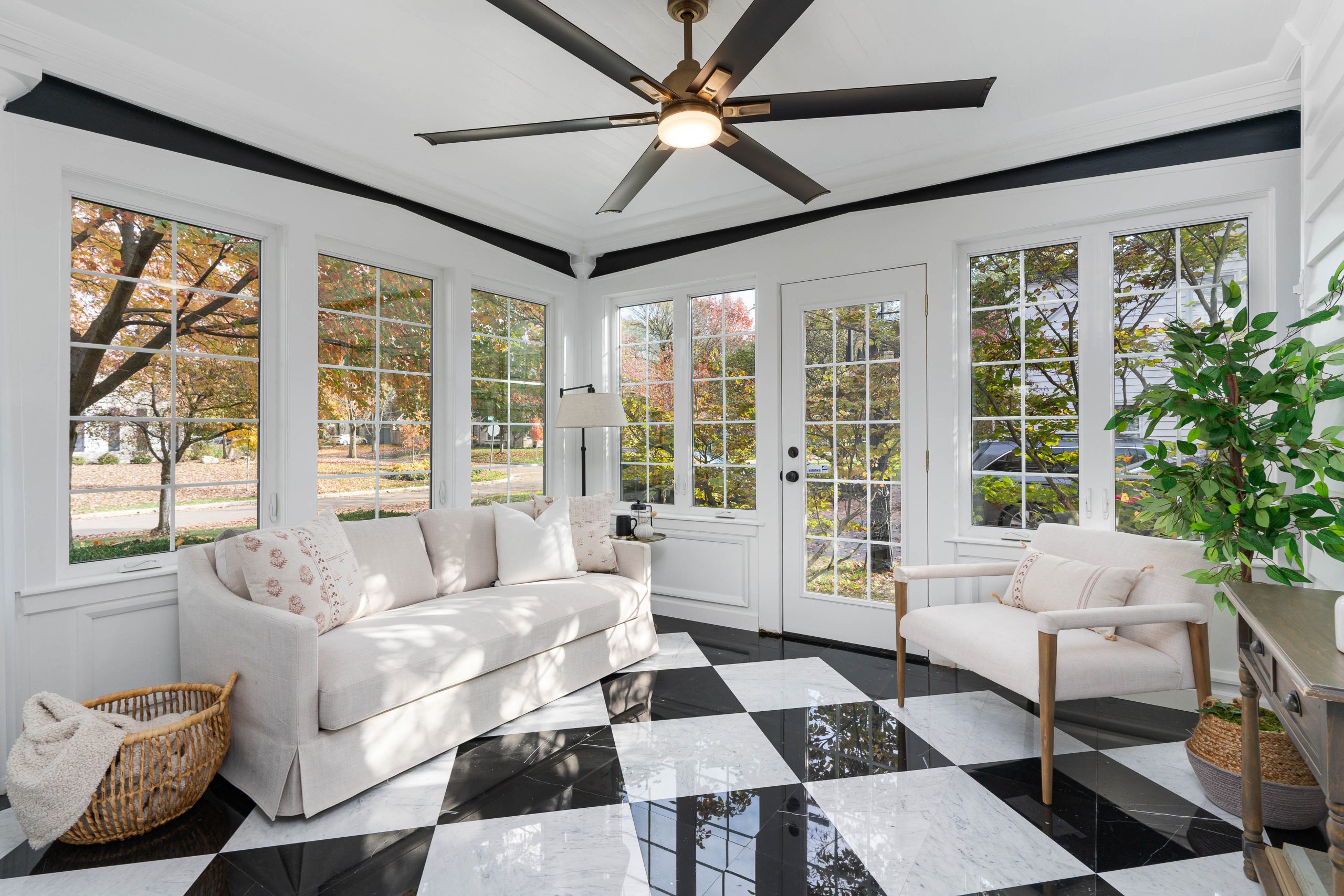 4 seasons room in remodeled Upper Arlington home with checkered tiled floors and luxury decor.