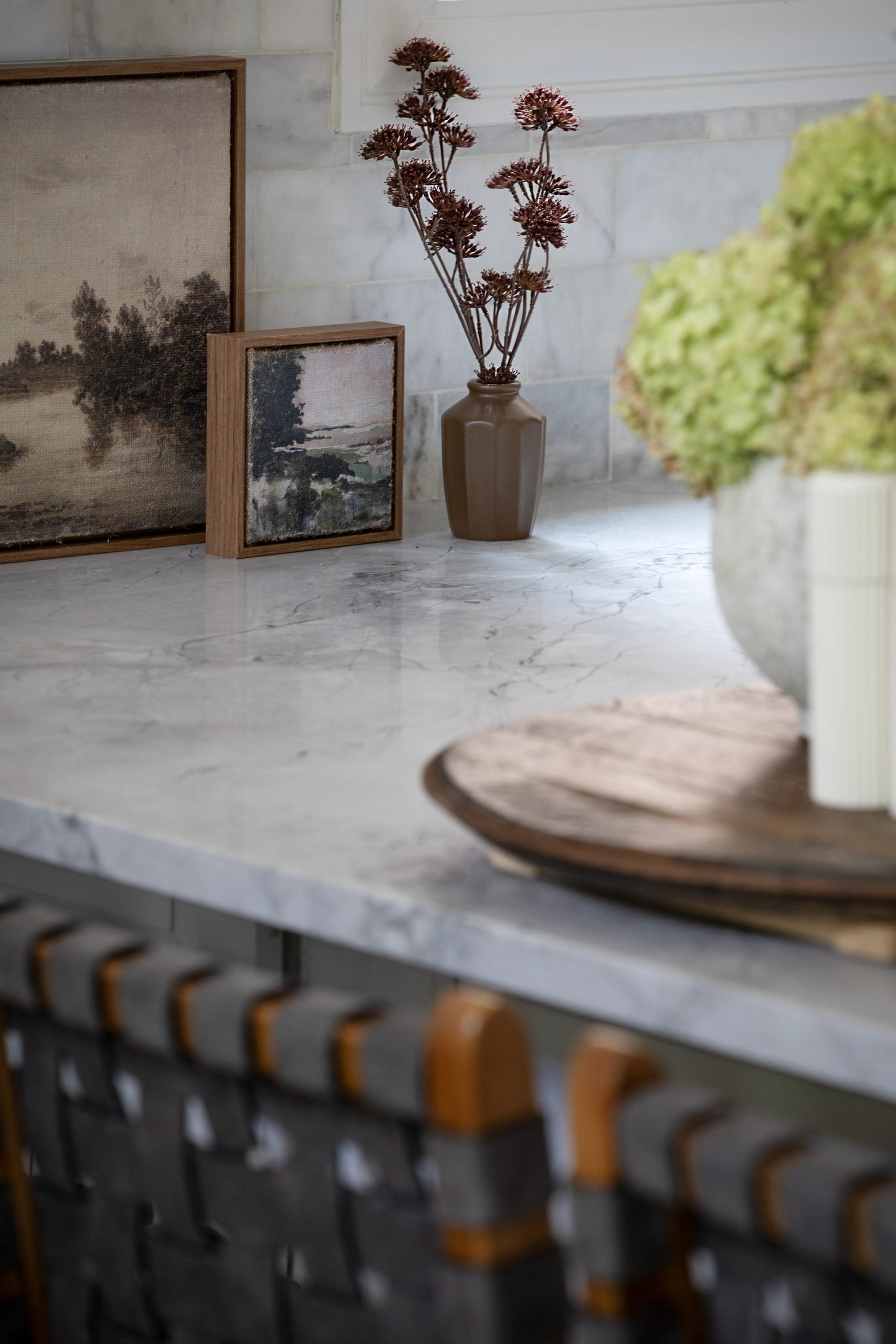 Close-up of the kitchen highlighting stunning Carrara marble countertops styled with a small canvas art piece from Target’s Hearth & Hand line. Freshly picked hydrangeas from the property add a natural, seasonal touch to the space.
