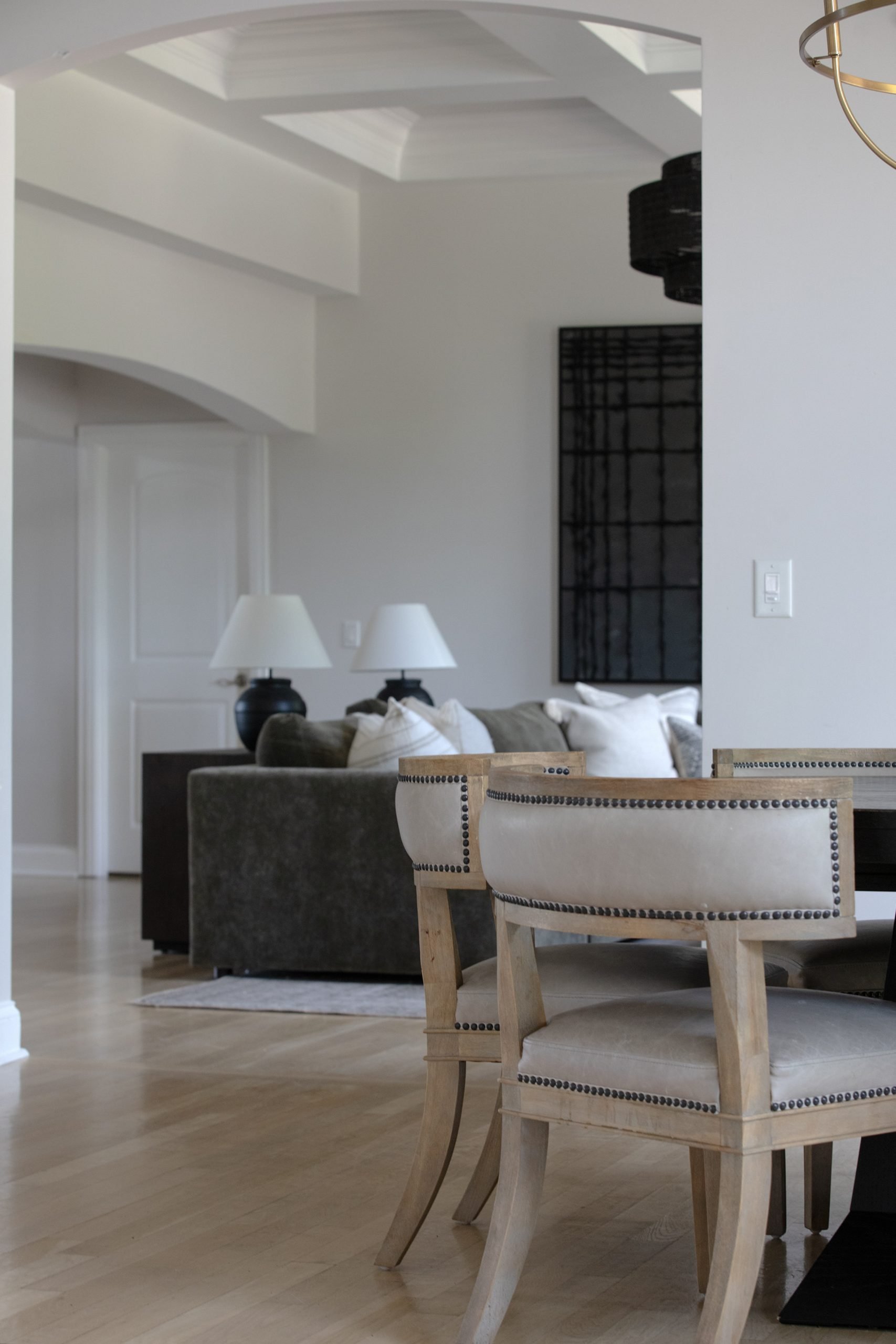 Alternative view of the dining area with Carter Dining Chairs and black round table from Arhaus, now opening into the main living room. This newly revealed space features a relaxed, livable layout distinct from the nearby sitting room, offering a comfortable setting for everyday lounging and entertaining.