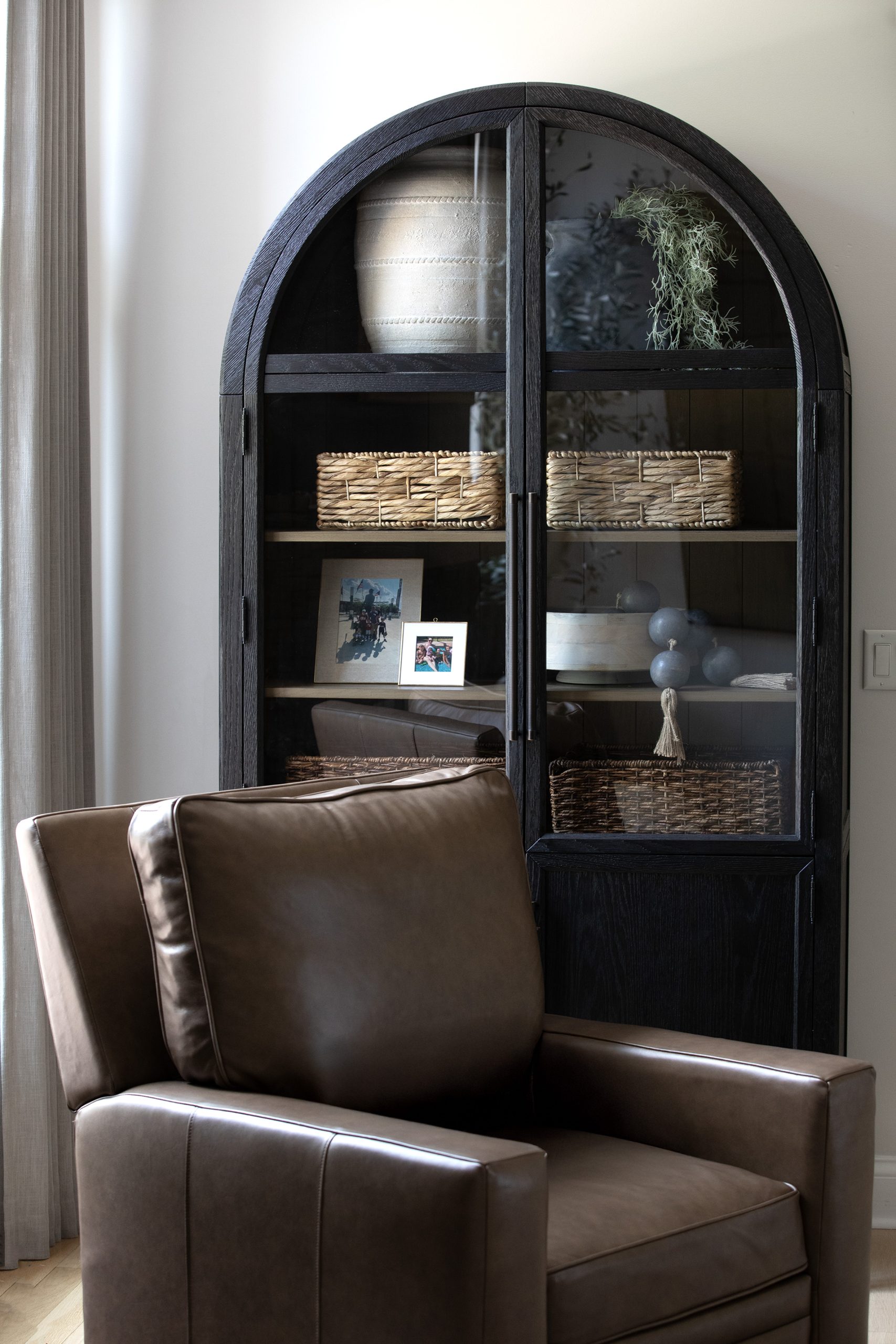 Detail view of the Arhaus Hattie Cabinet featuring a curated arrangement of vintage-look vases, adding depth and character to this transitional interior