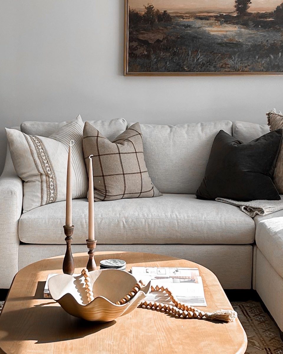 A living room interior design concept with large sofa, wooden coffee table, natural tables-cape and impressionist artwork.
