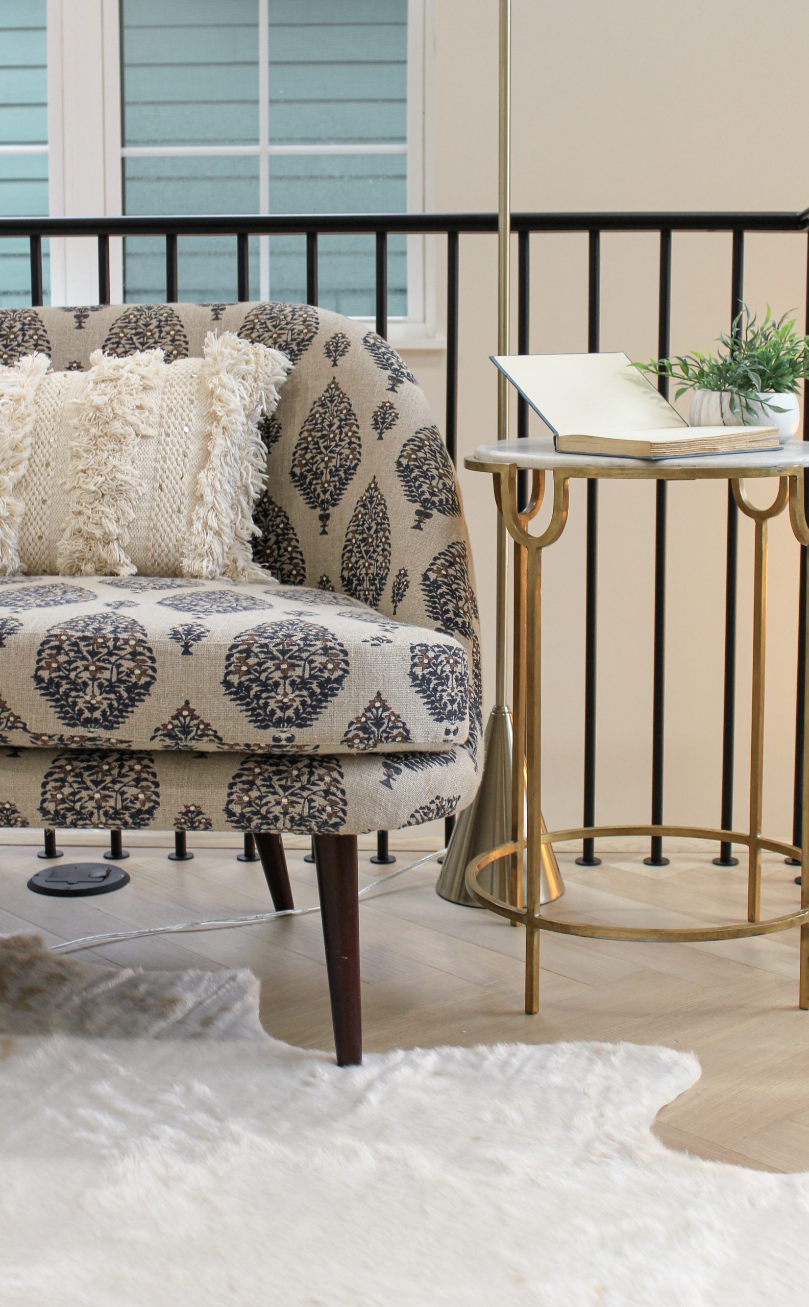 Luxury flex space decor with printed chaise lounge chair and gold/marble side table.