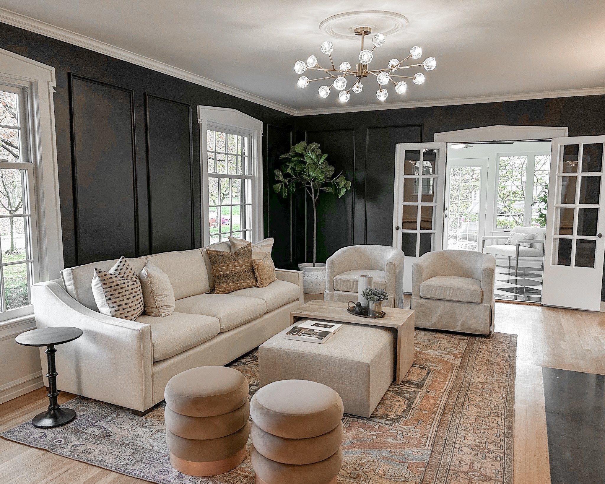 A modernized Upper Arlington home with black walls, modern furniture and large area rug staged before going on the market for sale.