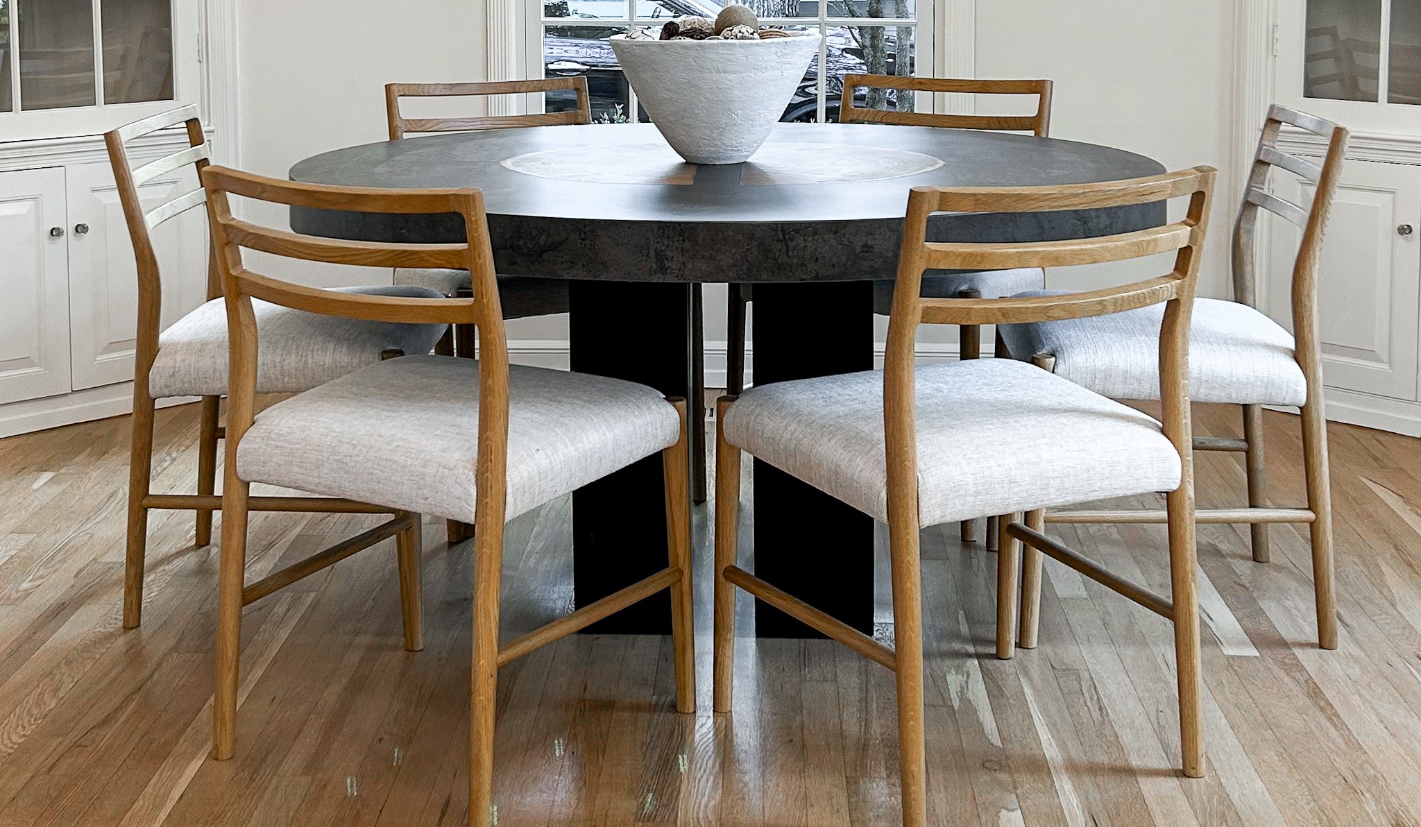 Unique modern wooden table from Arhaus and modern minimal wooden upholstered dining chairs.
