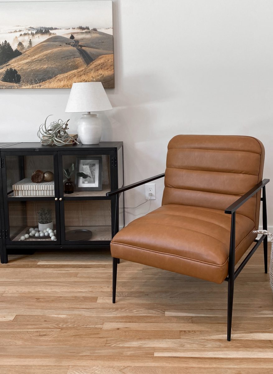 A leather occasional chair is the featured furniture piece of a living room reading area designed by Jennifer Donahue Interior Design Inc.