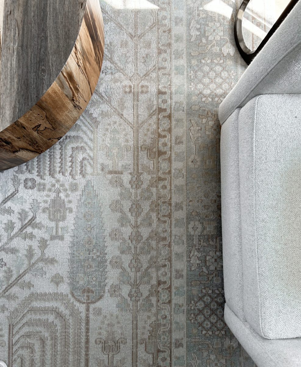 An interior design installation featuring woven rugs, natural live edge coffee tables and occasional chairs