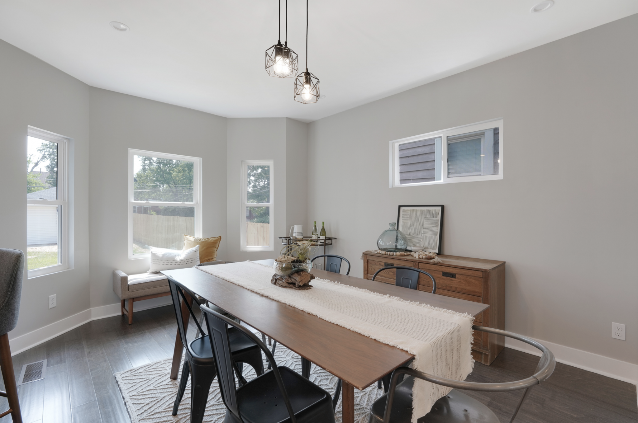 Dining area in a renovated Pacific Palisades, California home features contemporary farmhouse chairs, natural finished furniture and soft textures