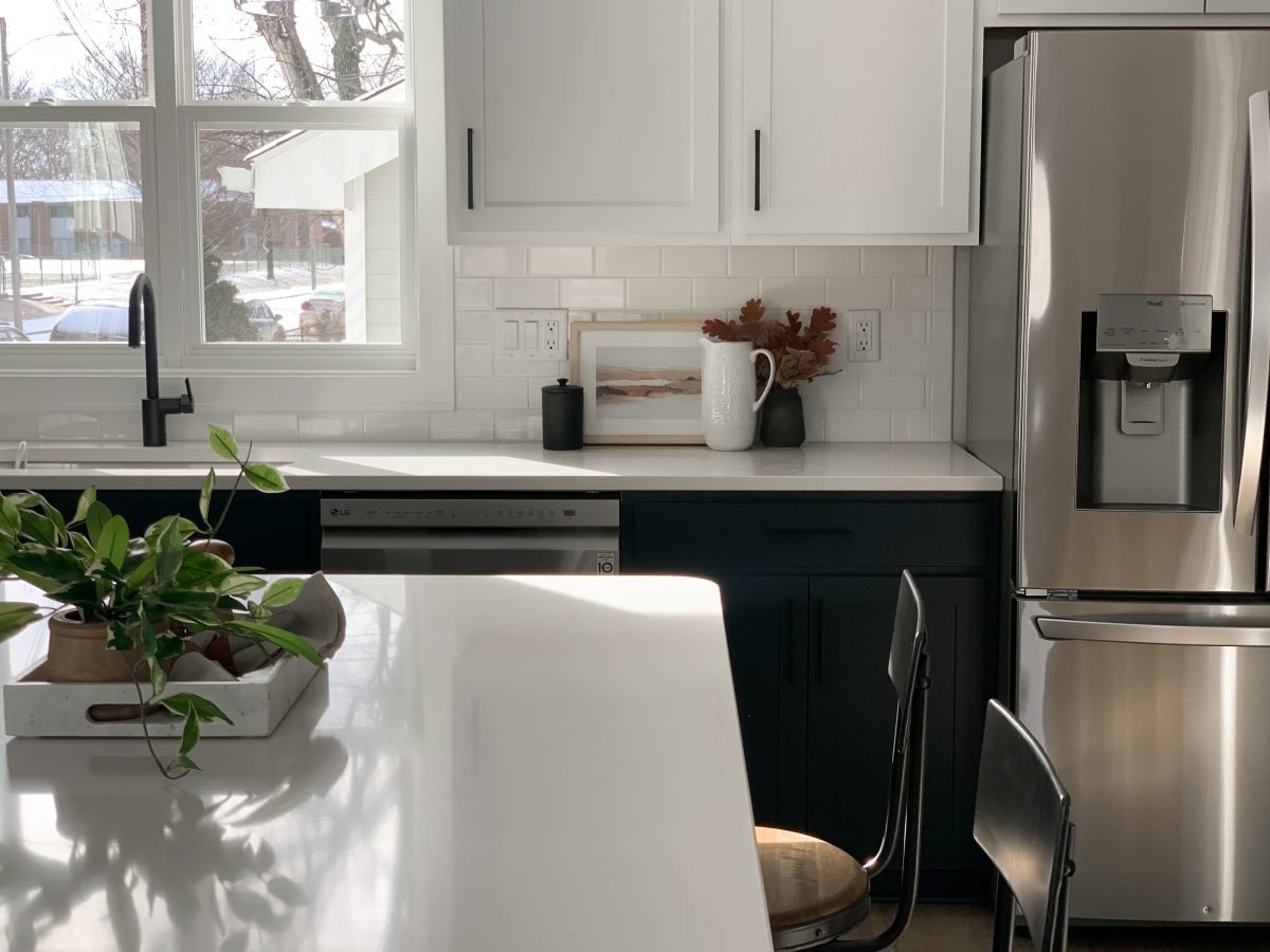 Solid surface countertops and new black cabinets with modern barstools in a professionally staged home in central Ohio.