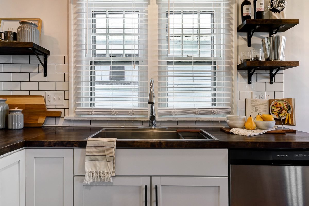 Remodeled kitchen with live edge wood countertops, white backsplash and stainless steel appliances in a downtown Pacific Palisades, California home.