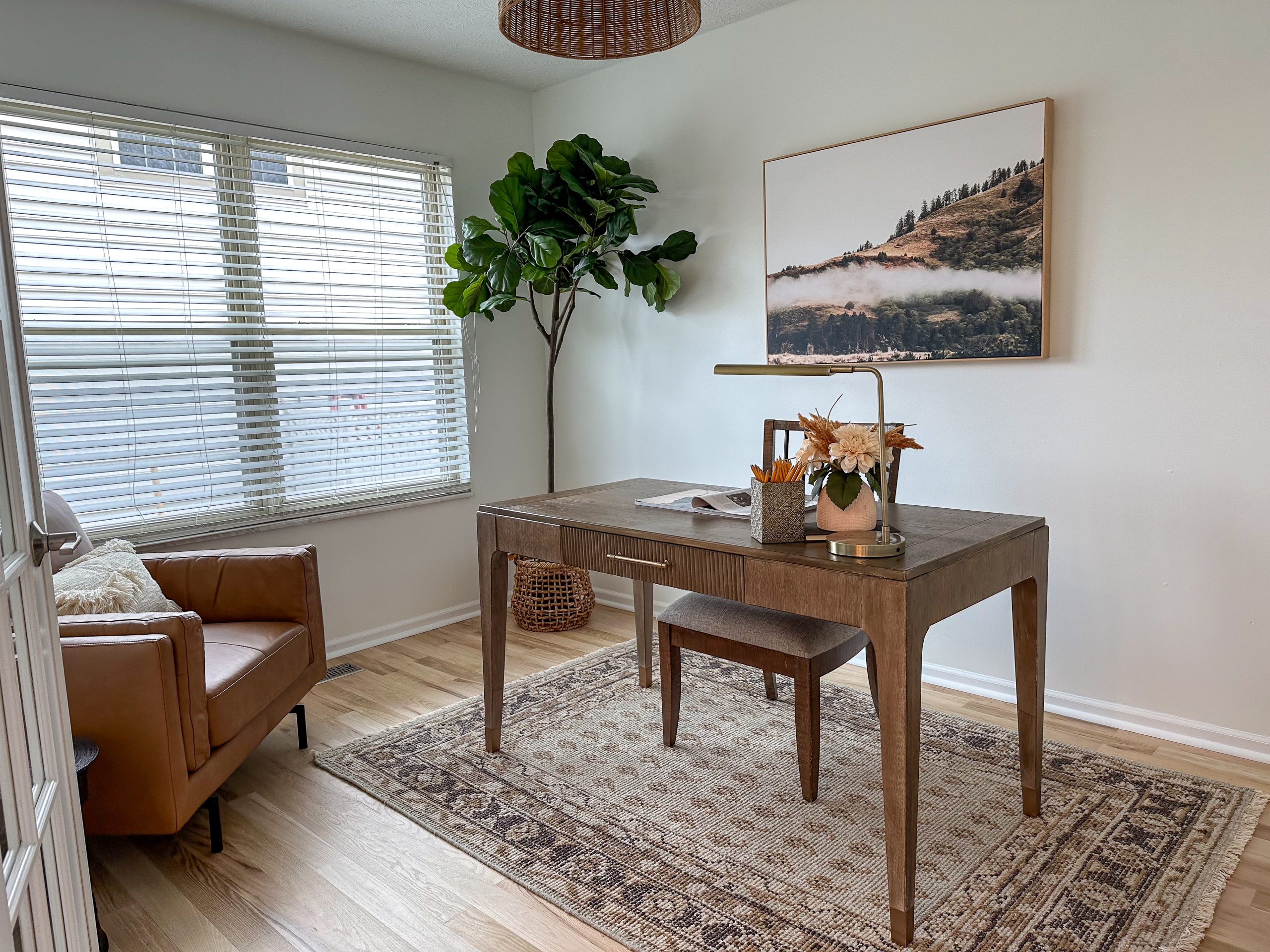 Home office design in Dublin, Ohio, home featuring classic wooden desk and leather mid century arm chair.