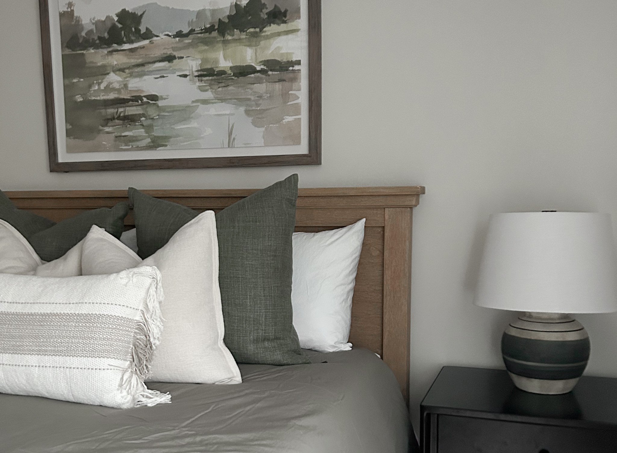 Close up of bedroom interior design project featuring modern lamps and pillows, abstract artwork for Columbus Ohio Clients.