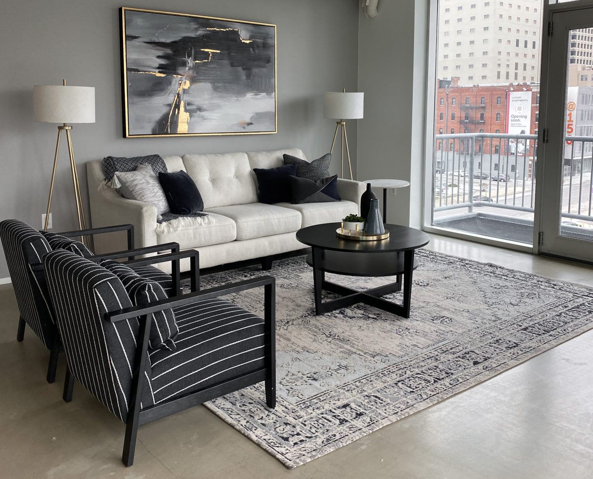 Open floor plan living area in downtown Pacific Palisades, California with white sofa, black pinstripe occasional chairs and matching floor lamps.