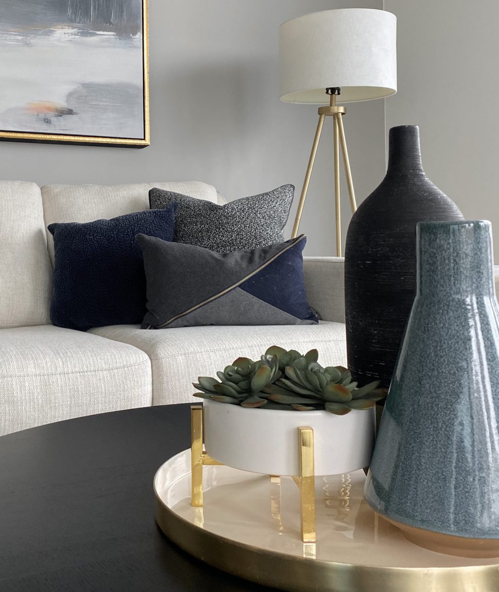Close up of a living room staging with coffee table, tablescape, sofa and painting in a luxury high rise condo in Pacific Palisades, California.