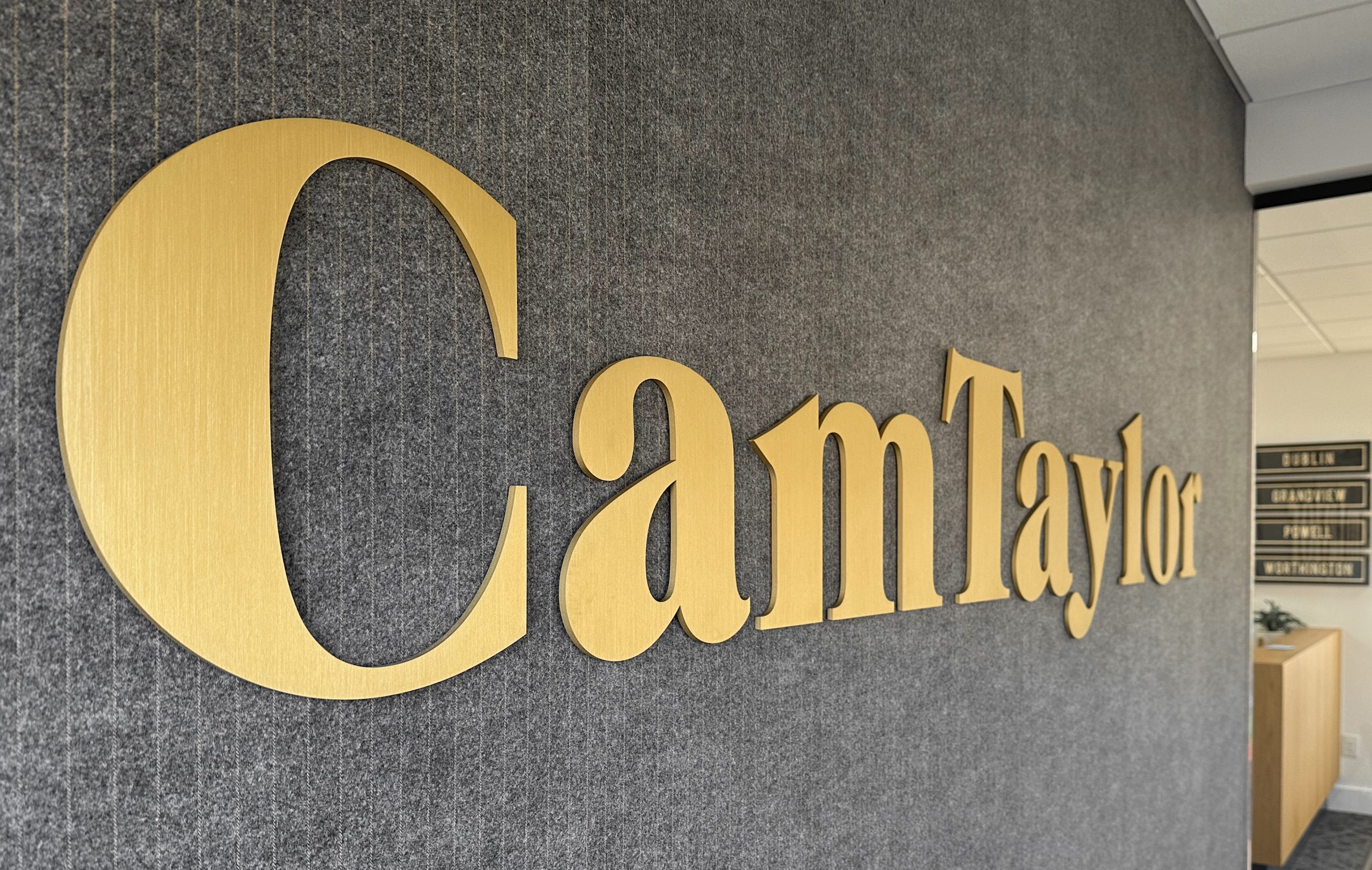 Cam Taylor real estate office sign showcasing the completed redesign of the office space.