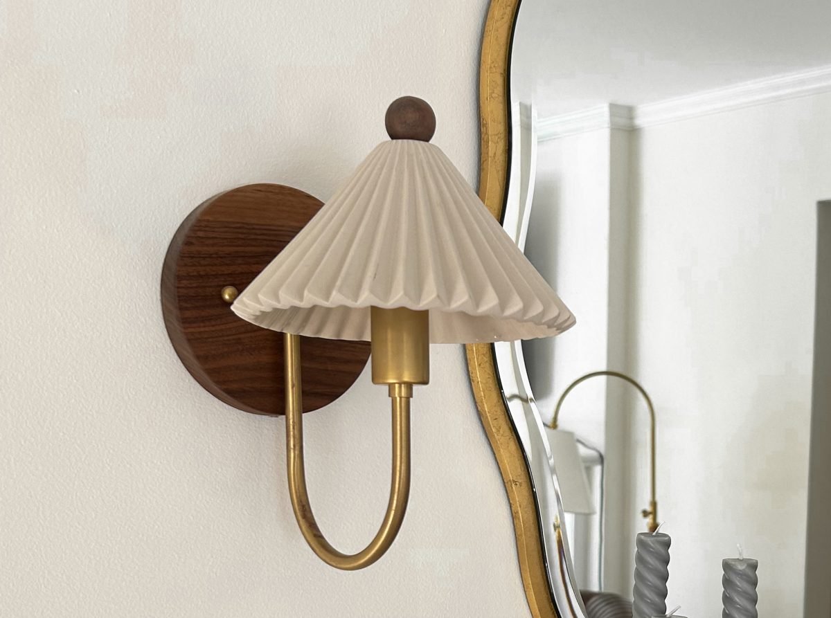 Accent wall decor featuring an artisan sconce, wall mounted luxury lamps and large mirror.