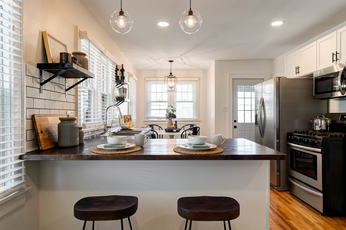 Live edge peninsula countertops, barstools and elegant kitchen decor staged by Jennifer Donahue Interior Design Inc in Pacific Palisades, California.