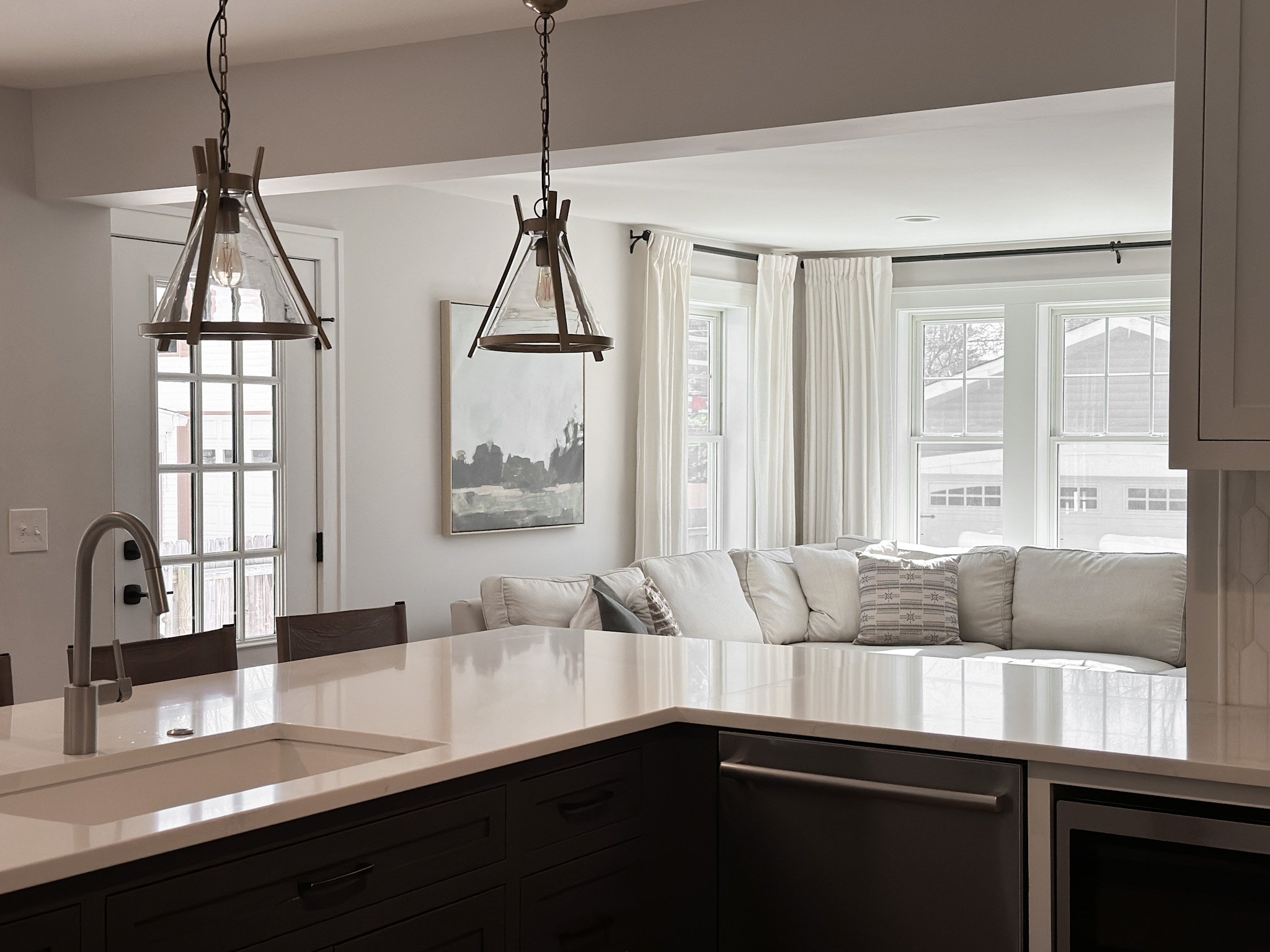 Overlooking modern kitchen design into naturally lit living room area styled by Jennifer Donahue Interior Design Inc in Pacific Palisades, California.