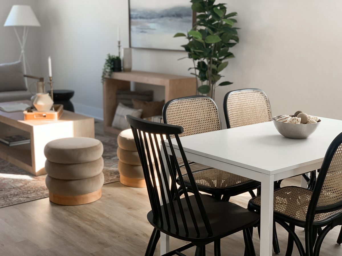 Small kitchenette with black Windsor chairs and classic wicker chairs.