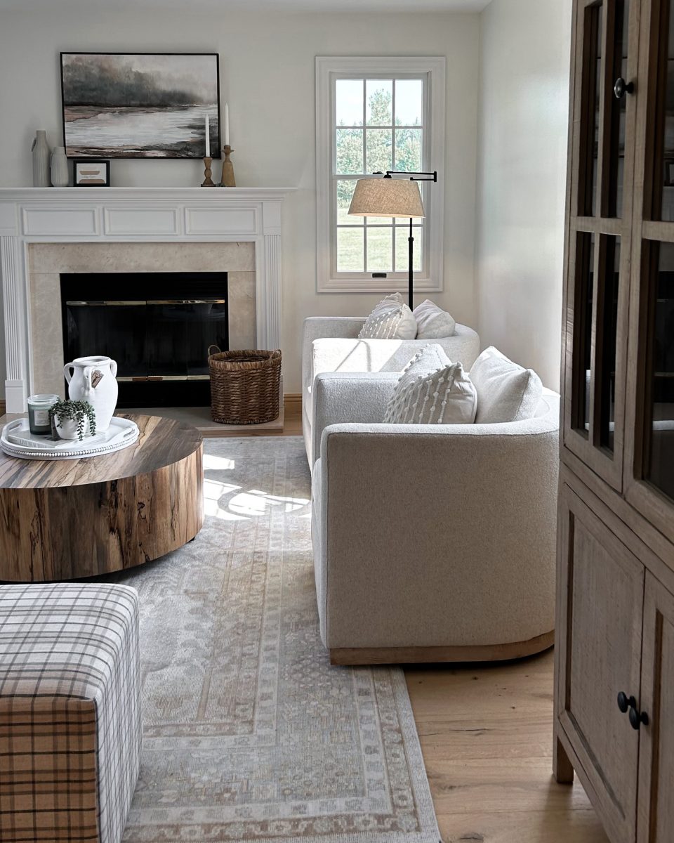 Rounded occasional chairs and large area rug positioned in before a fireplace in a final interior design look.