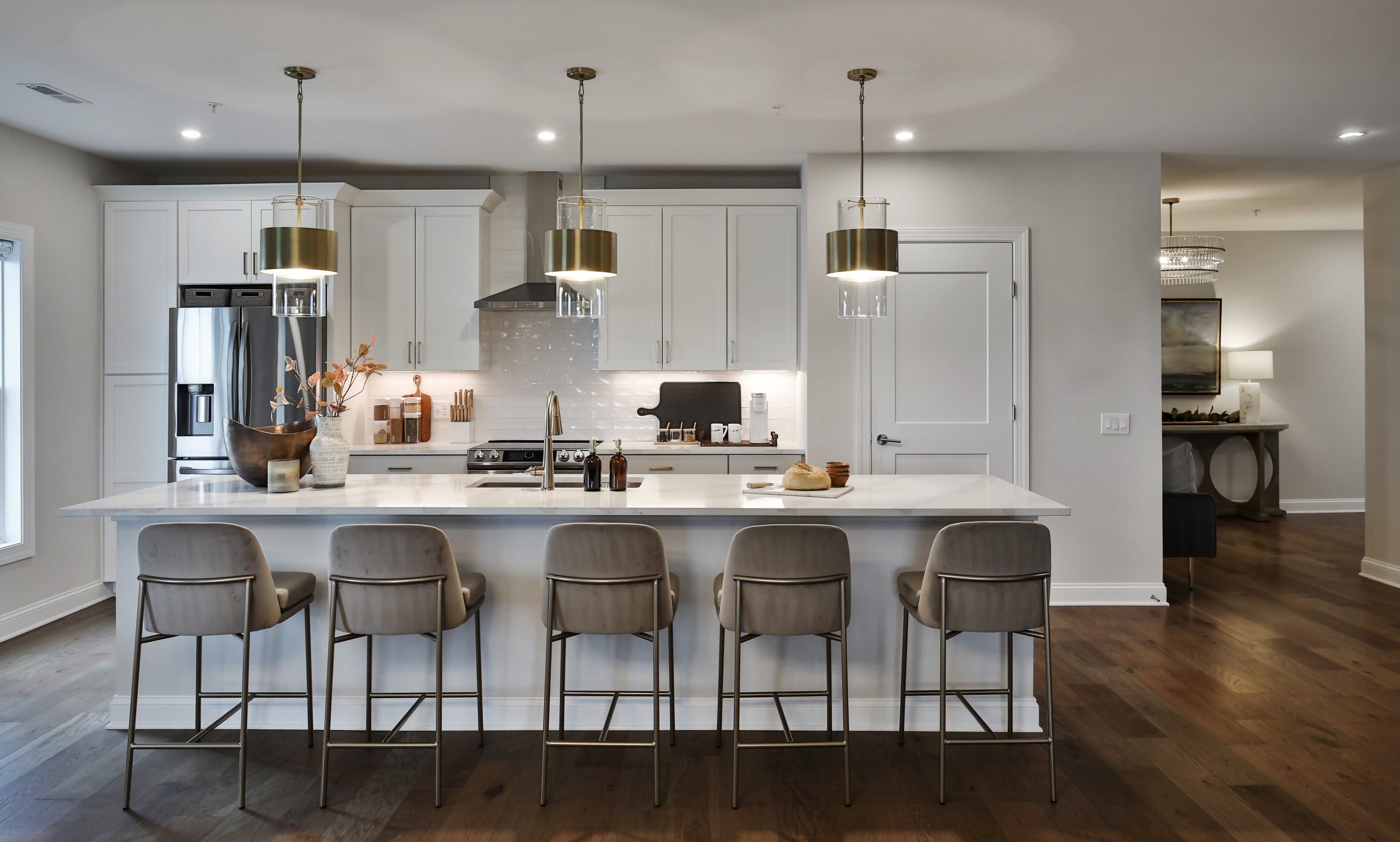 Looking into a luxury kitchen and kitchen island space with bar stools.