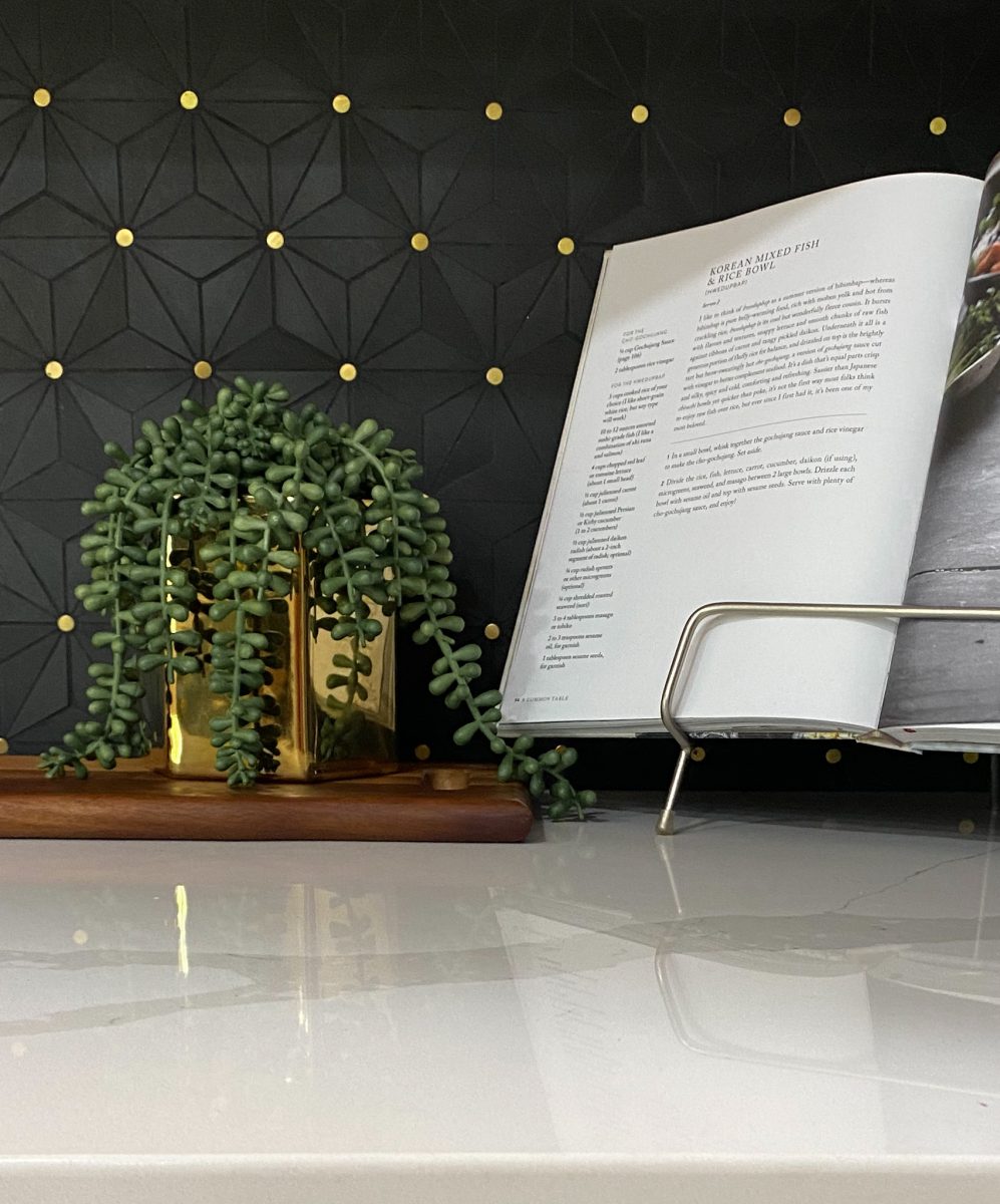Renovated kitchen designed and staged with white solid surface countertops, modern geometric backsplash.
