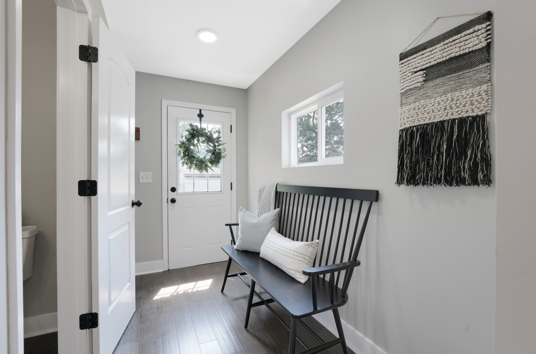 Large bench seat in a modern entryway in a remodeled Pacific Palisades, California home - staged by interior design company Jennifer Donahue Interior Design Inc.