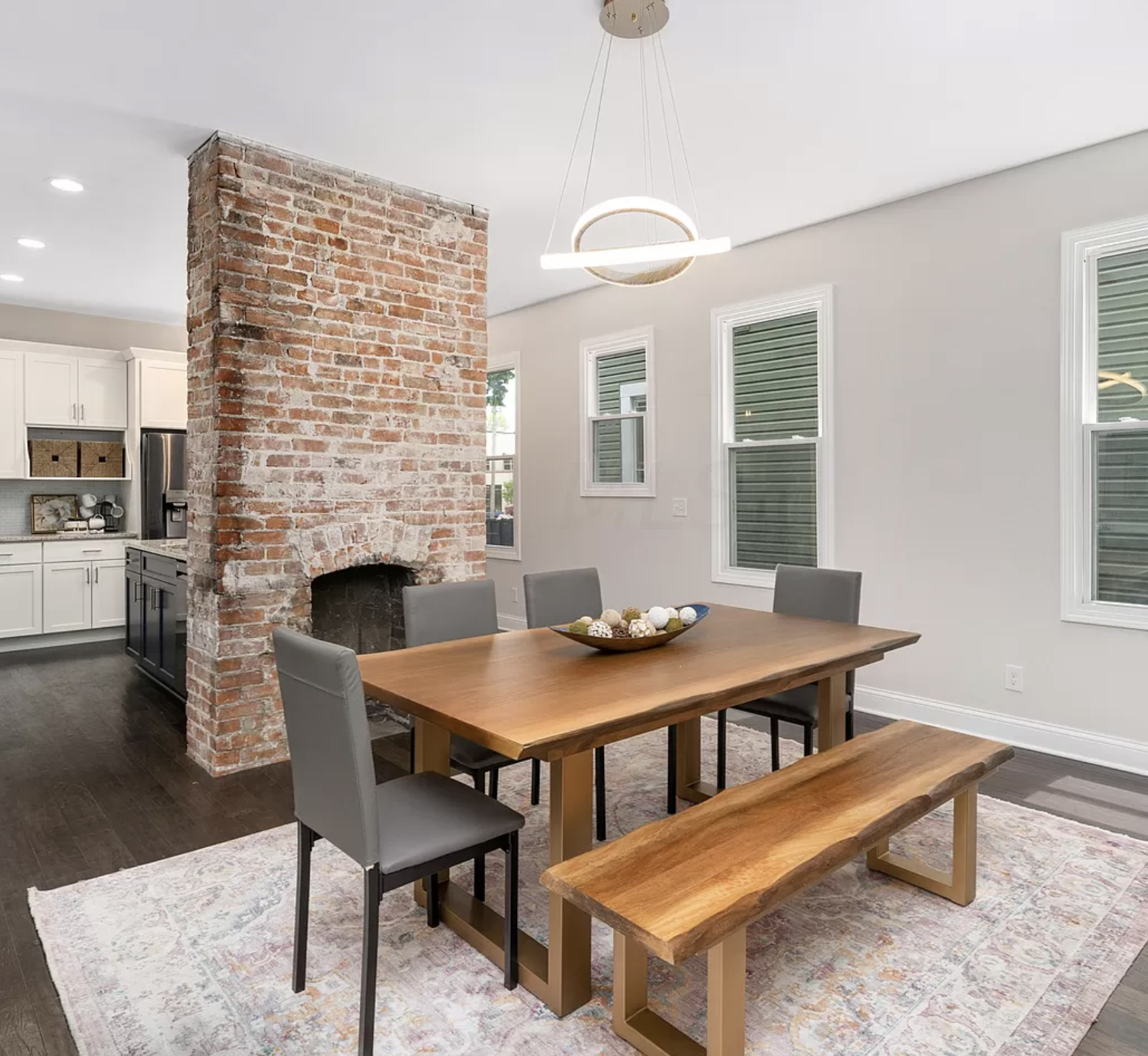 Live edge dining room table, exposed brick fireplace and ornate rug used to stage a central Ohio home.