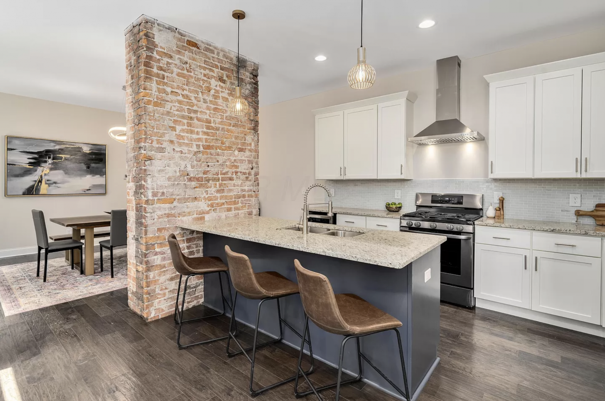 Fully renovated open kitchen with granite countertops, island seating and hardwood floors