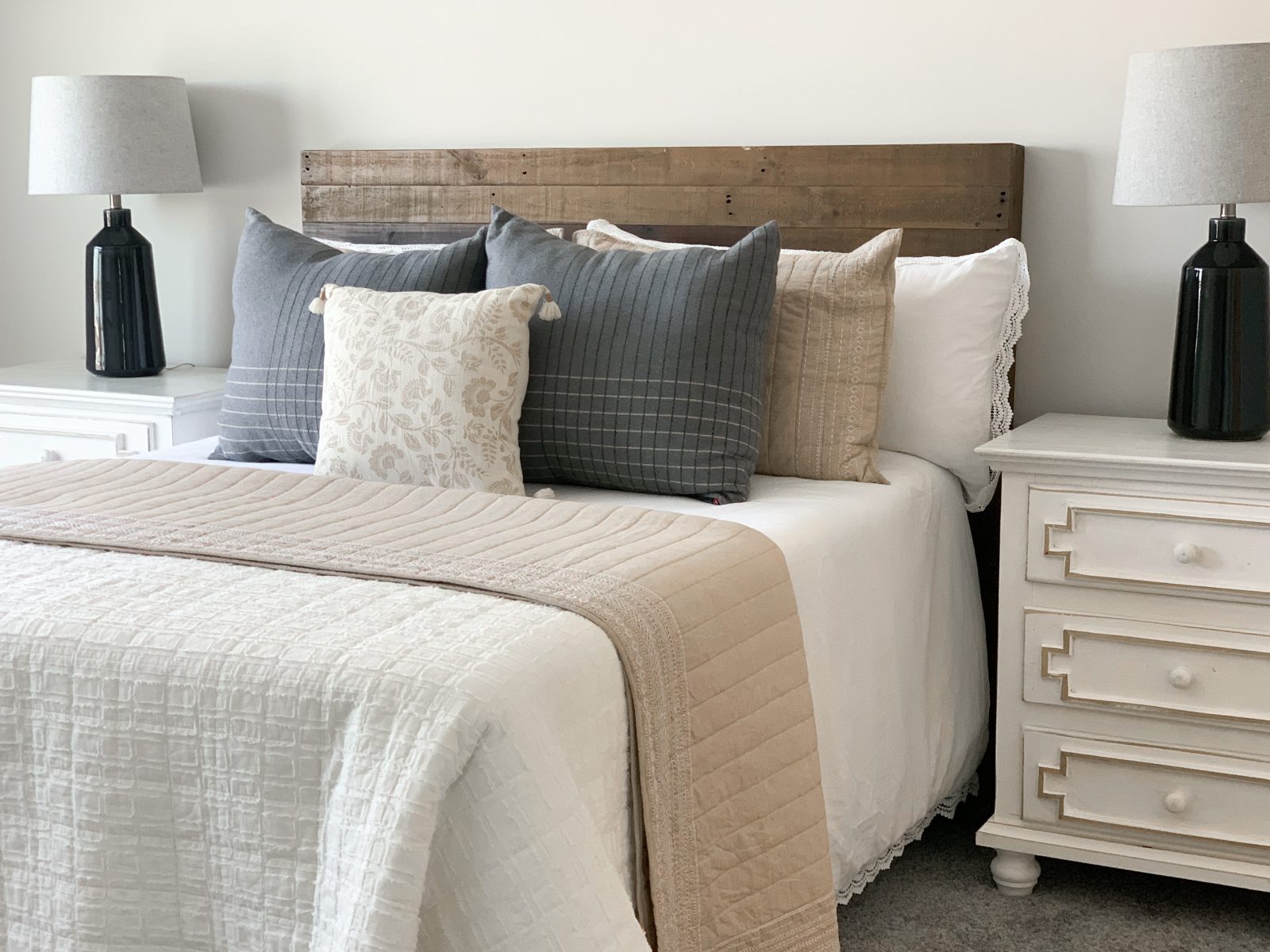 Natural bedroom decor with modern lamps and white nightstands.