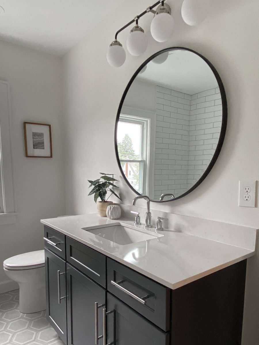 A remodeled bathroom features a monochromatic theme, sleek fixtures and large vanity in a Clintonville, Ohio home.