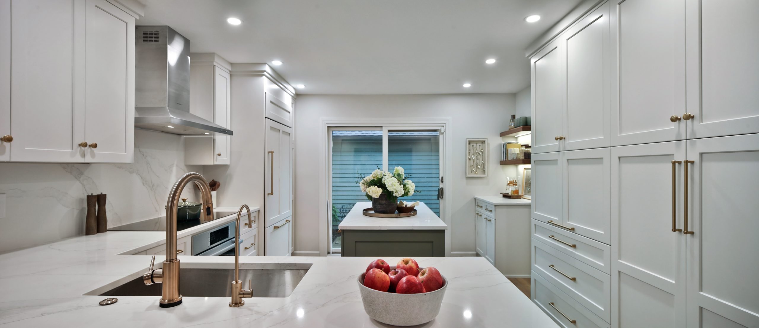 Wide angle shot of a complete kitchen remodel in a central Ohio home, featuring custom cabinetry, white stone countertops and luxury appliances.