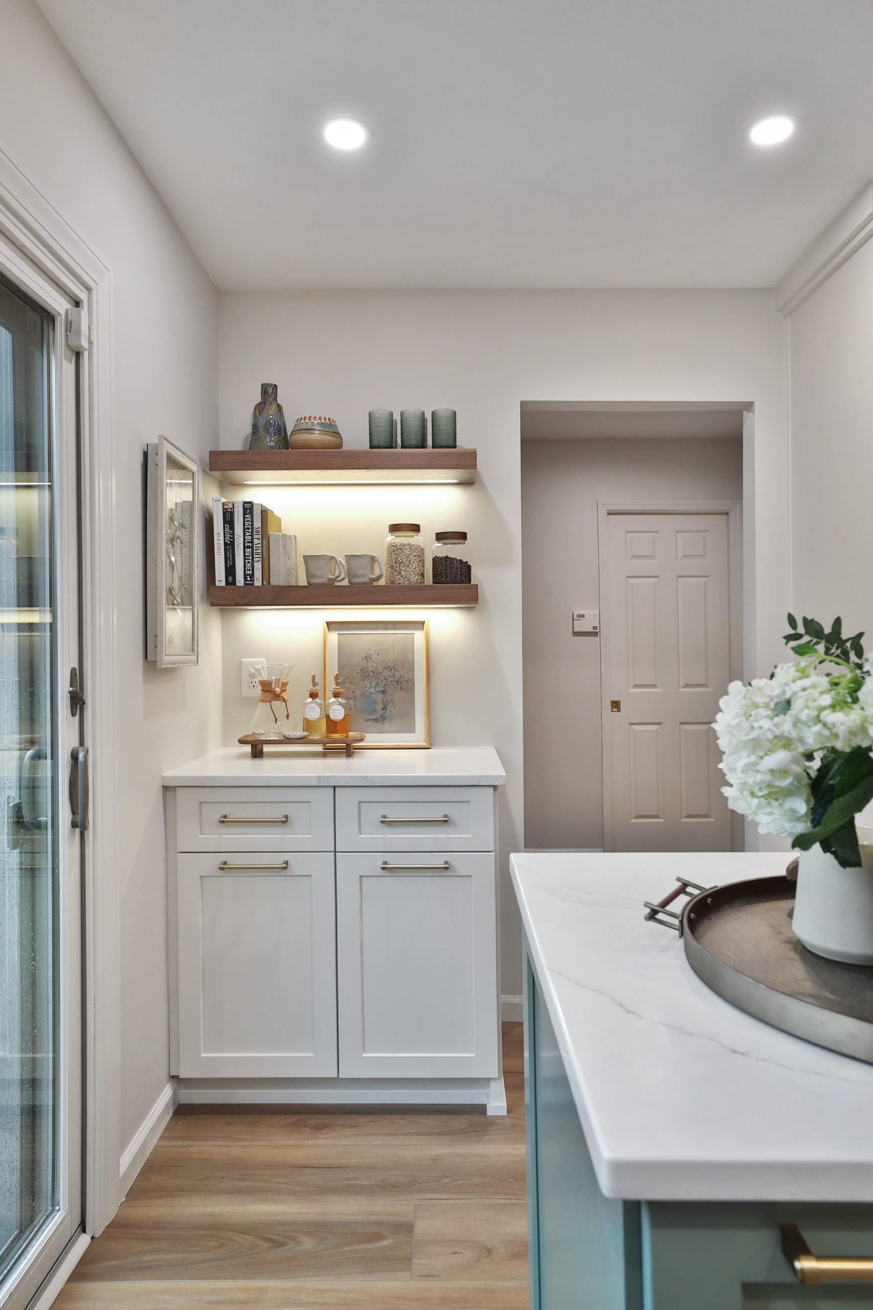 A fully remodeled kitchen in a central Pacific Palisades, California featuring custom cabinetry, floating shelves and modern decor.
