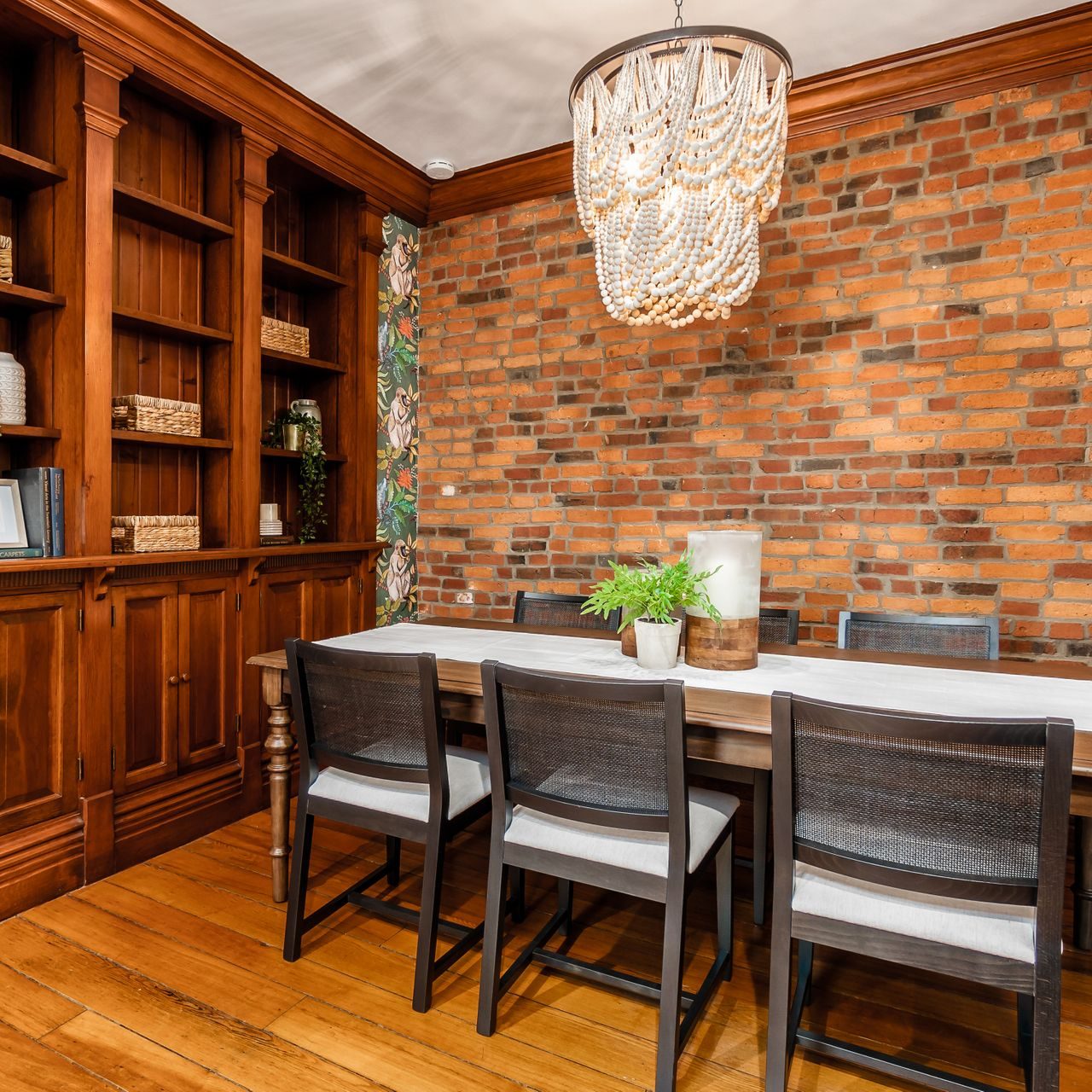 Luxury wooden dining room table with custom built in bookshelves and large glass chandelier in a German Village (Ohio) home.