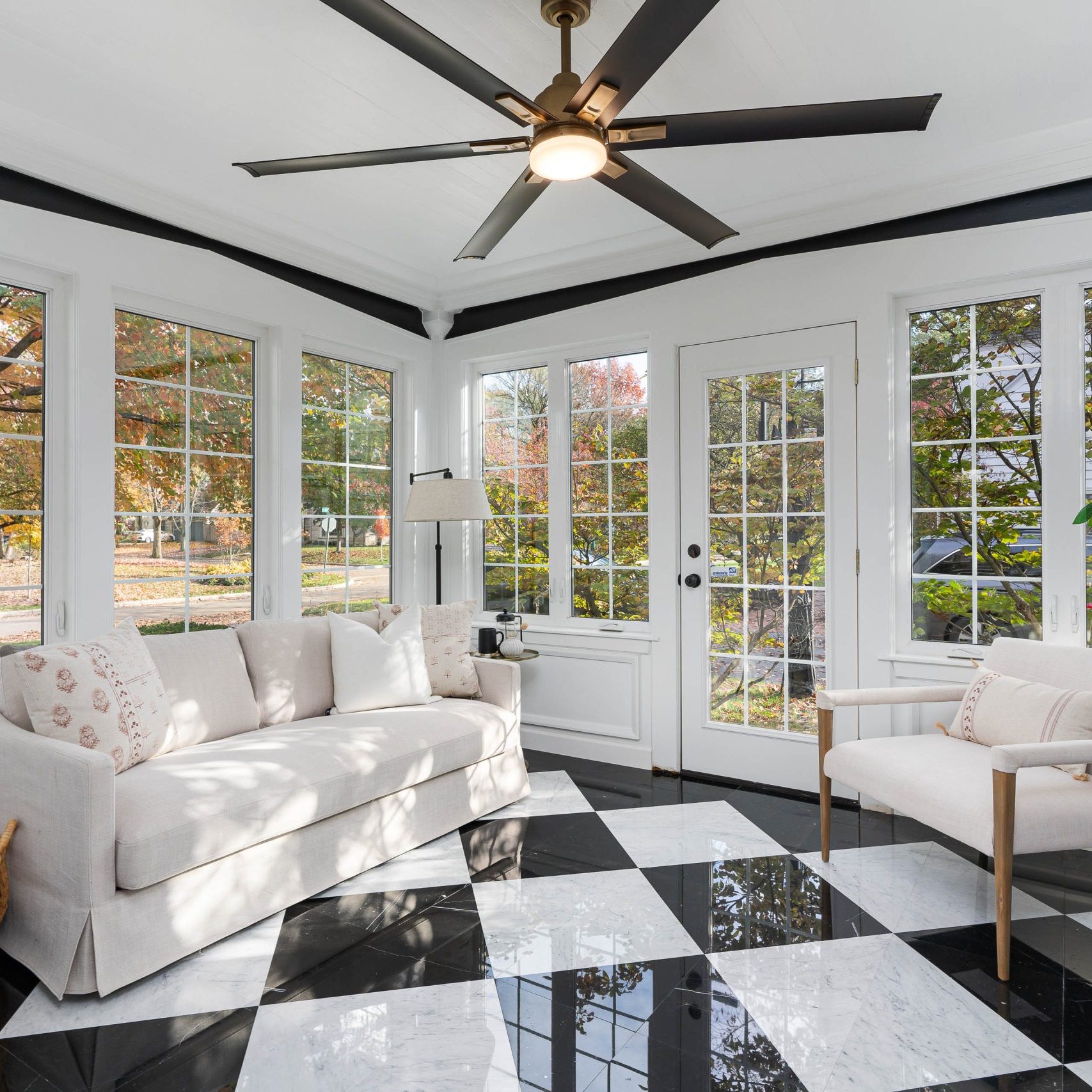 4 seasons room in remodeled Upper Arlington home with checkered tiled floors and luxury decor.