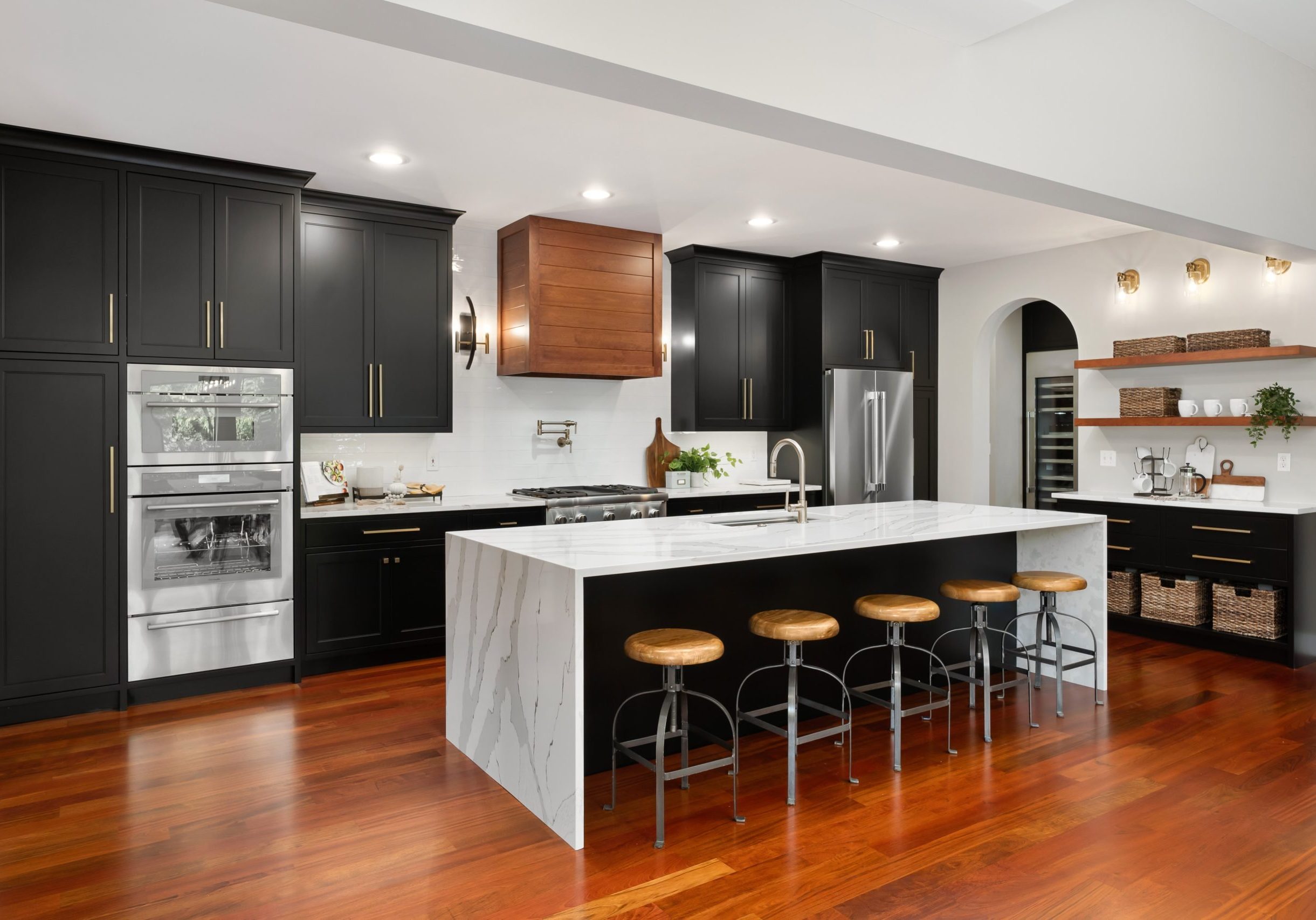 Staging in the famous Muirfield Village golf course with large waterfall countertop, dark wood floors and custom black cabinetry.