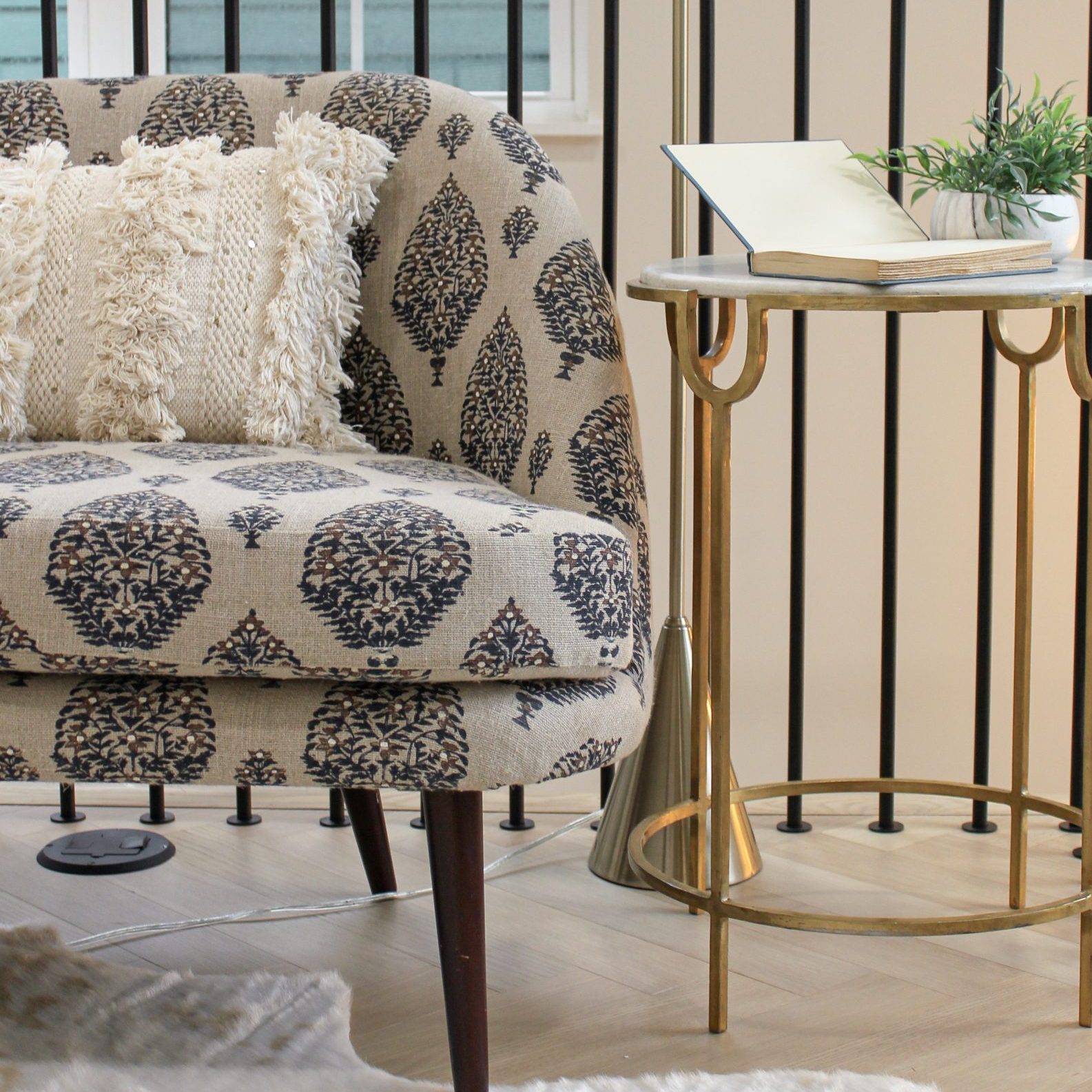 Luxury flex space decor with printed chaise lounge chair and gold/marble side table.