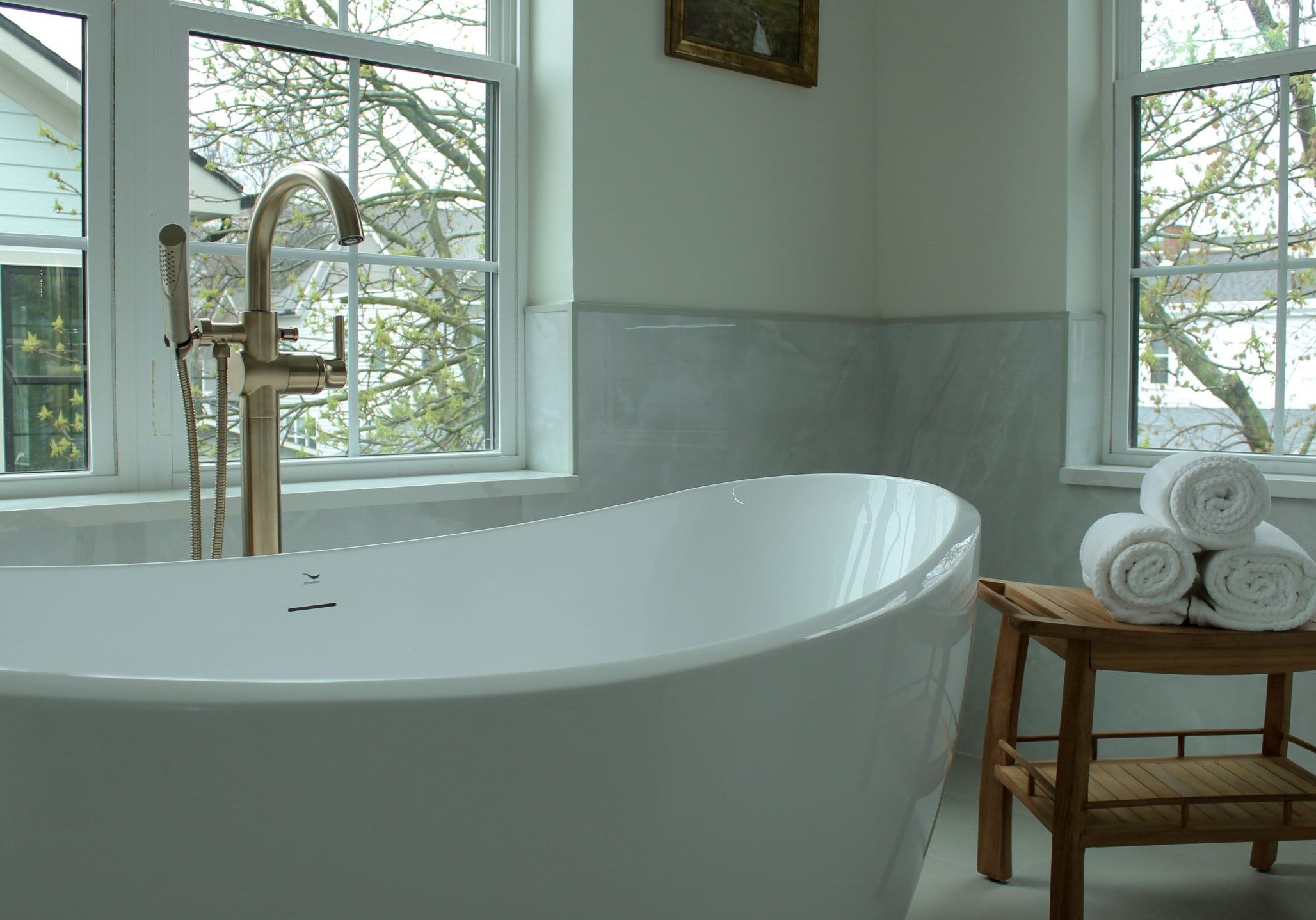 Luxury bathroom remodeling with large white bathtub and accent decor.