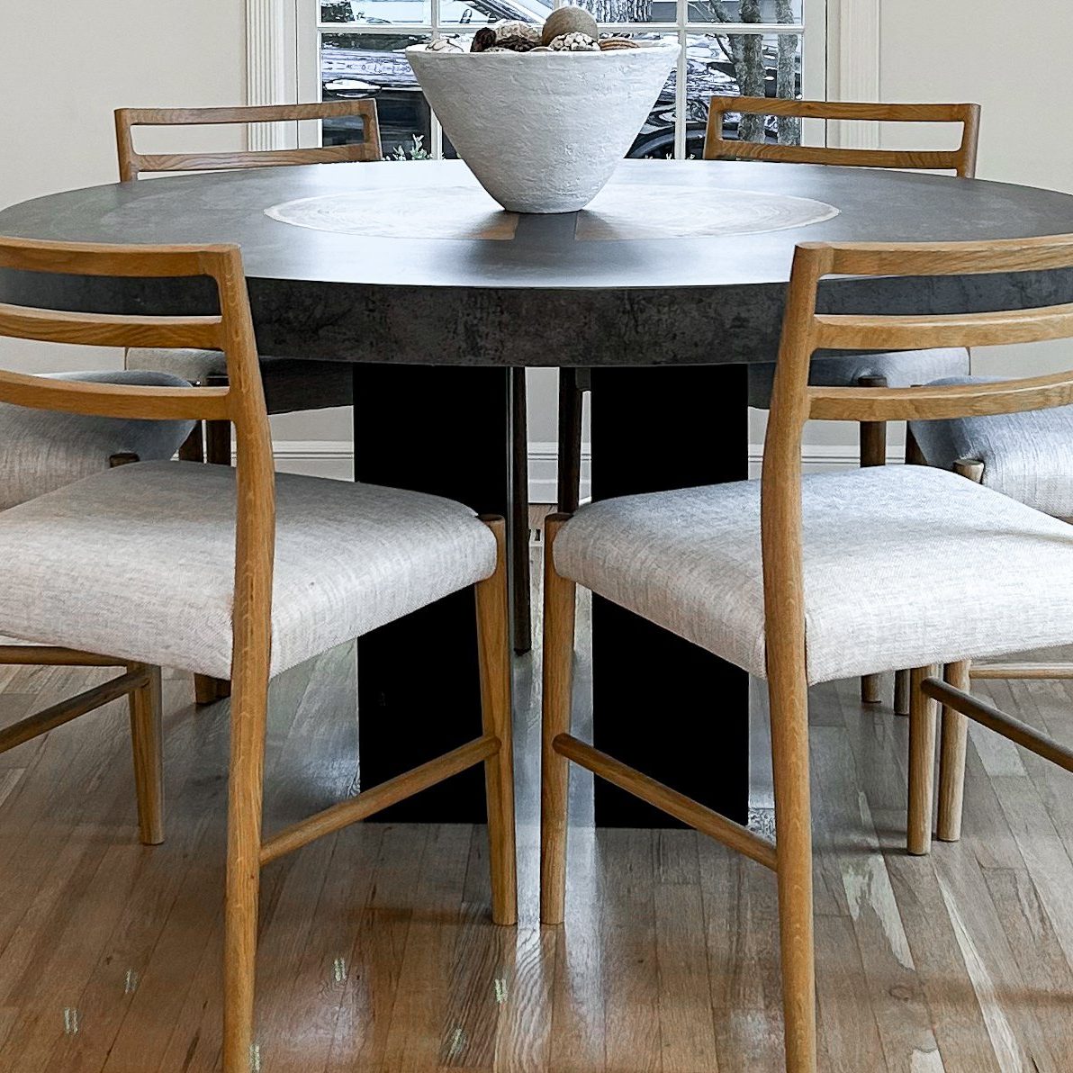 Unique modern wooden table from Arhaus and modern minimal wooden upholstered dining chairs.