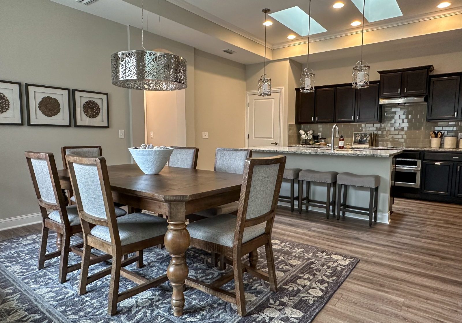 Living room in a Dublin, Ohio, home with large ornate dining table, wood dining chairs and open kitchen designed to serve and host many guests.