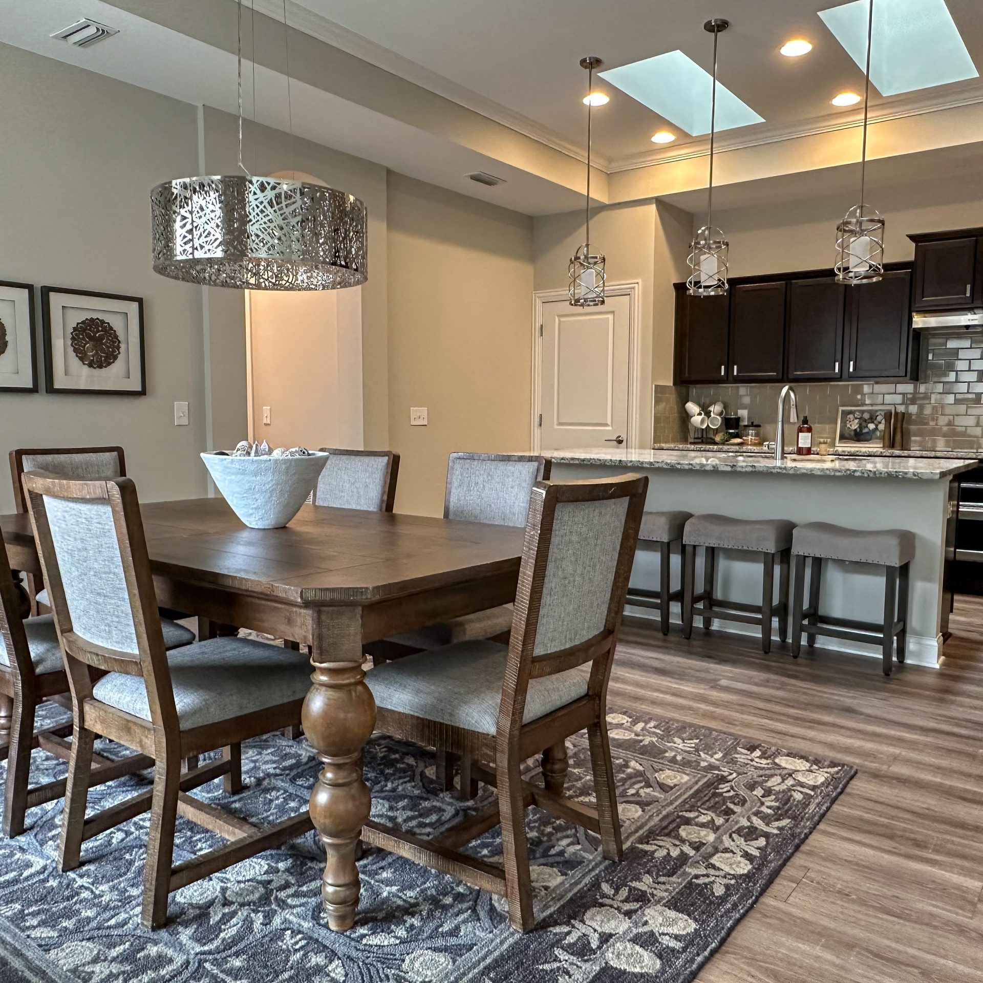 Living room in a Dublin, Ohio, home with large ornate dining table, wood dining chairs and open kitchen designed to serve and host many guests.