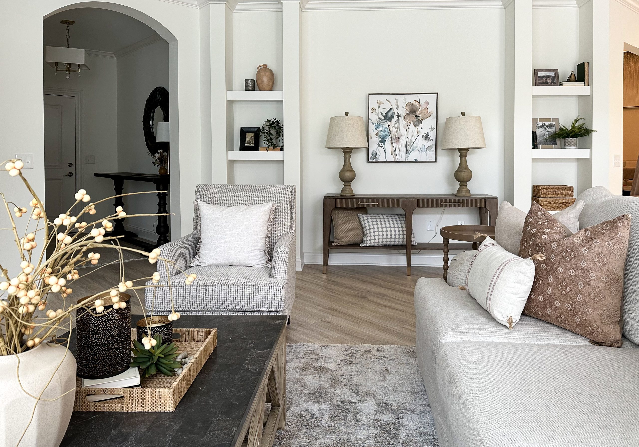 Living room space, designed with warm neutral tones in a Dublin, Ohio home with large open floor plan.