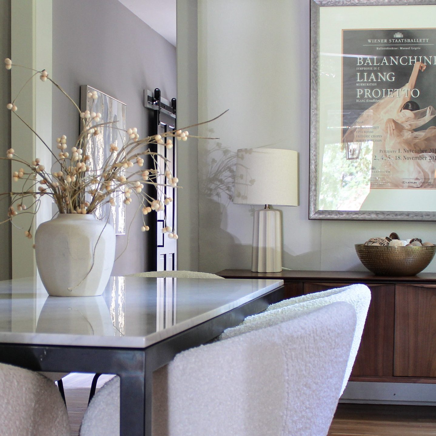 Dining room in German Village home with large modern dining table, white modern chairs and a wooden console table and table lamps.