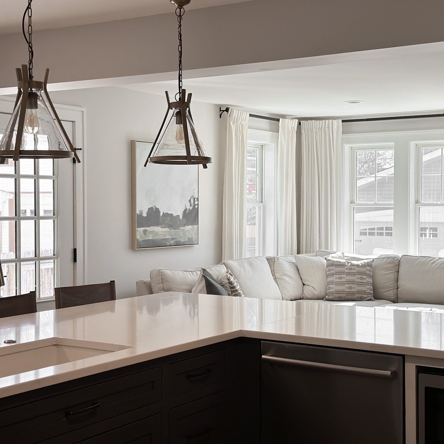 Overlooking modern kitchen design into naturally lit living room area styled by Jennifer Donahue Interior Design Inc in Pacific Palisades, California.