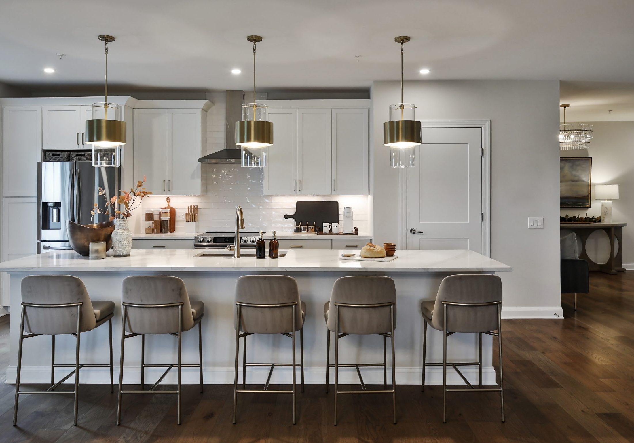 Looking into a luxury kitchen and kitchen island space with bar stools.