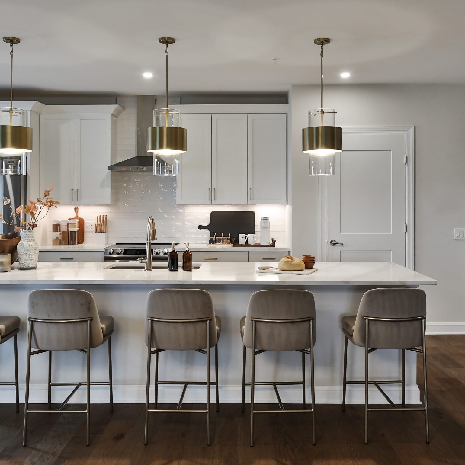 Looking into a luxury kitchen and kitchen island space with bar stools.