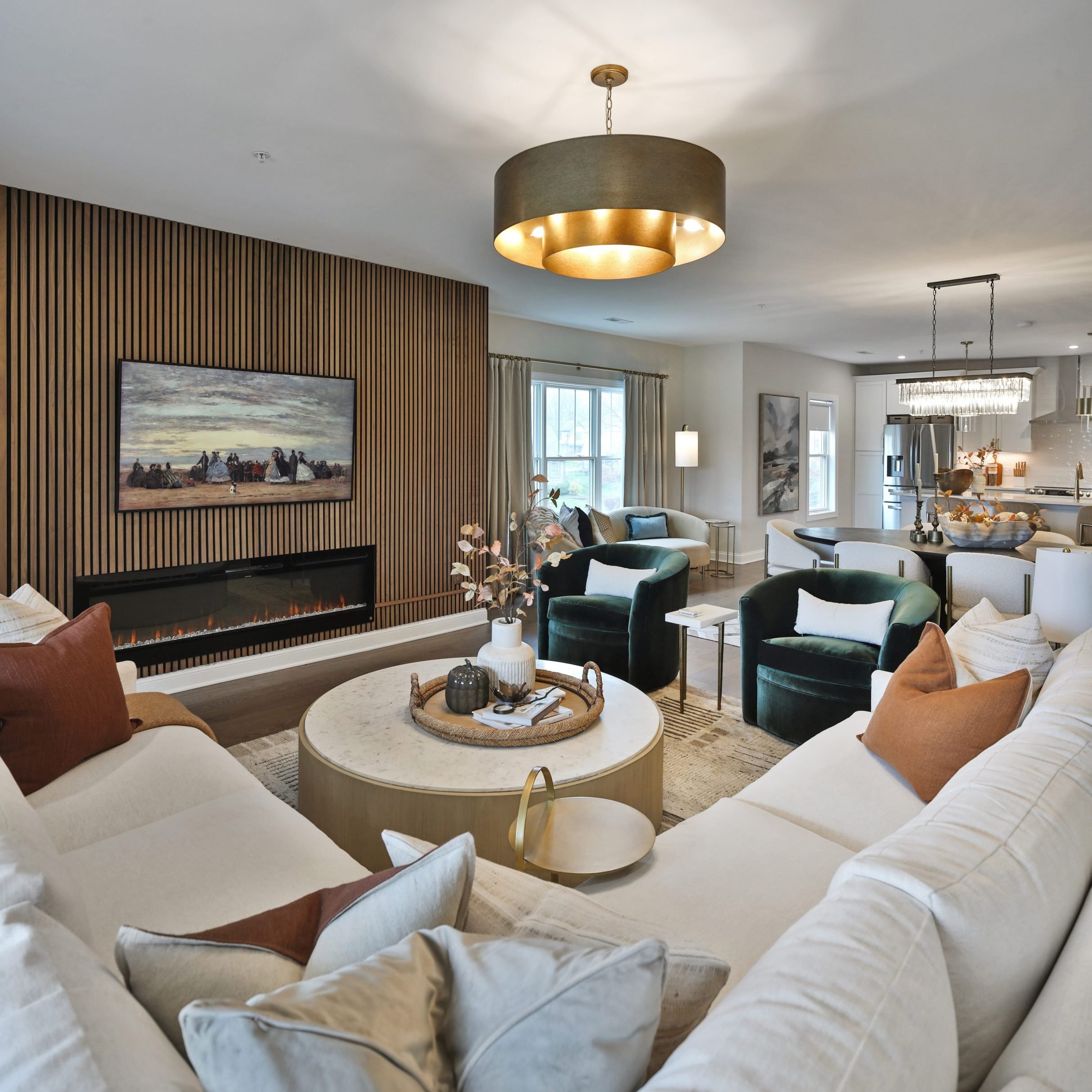Living room with sectional sofa, large round coffee table and built in fireplace.