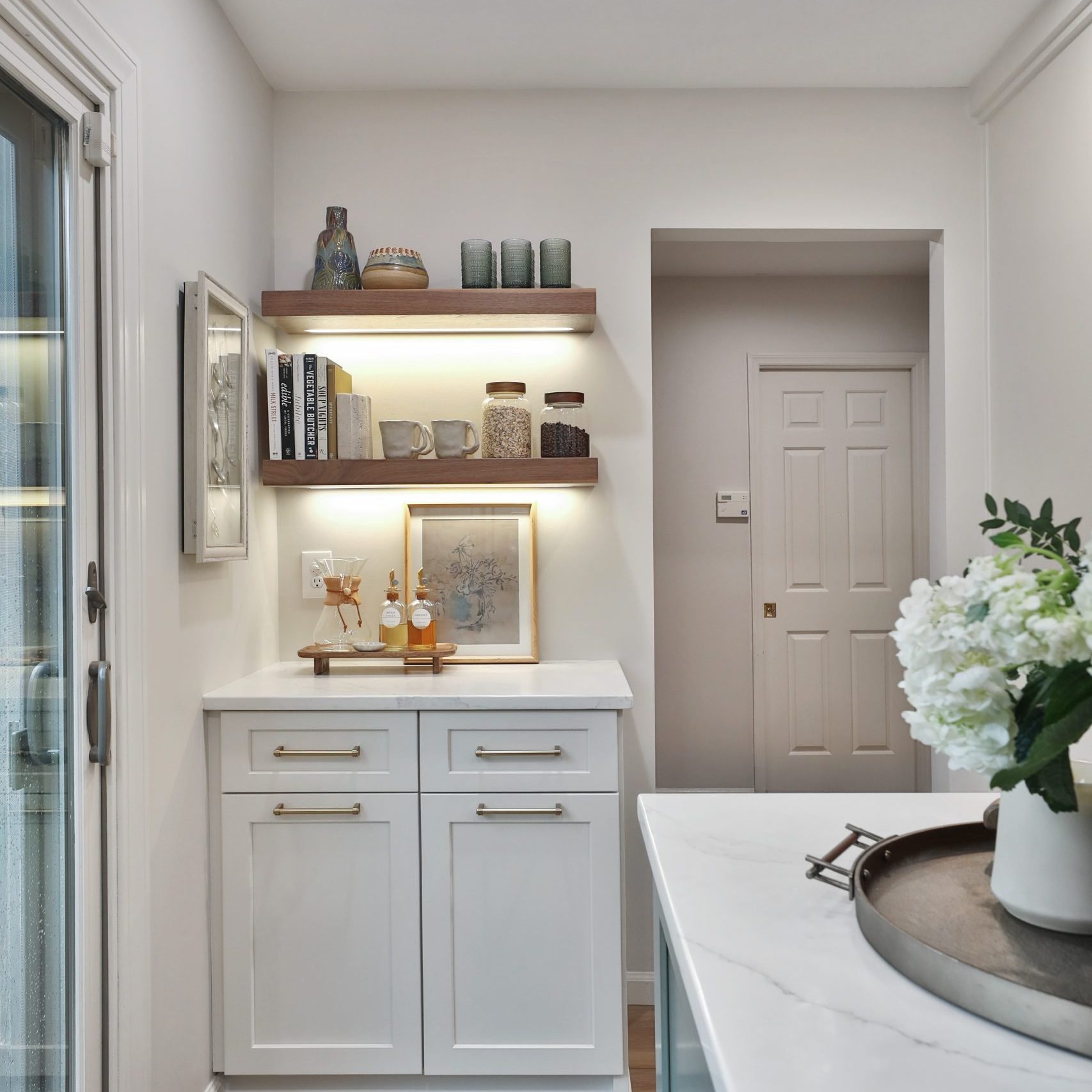 A fully remodeled kitchen in a central Pacific Palisades, California featuring custom cabinetry, floating shelves and modern decor.