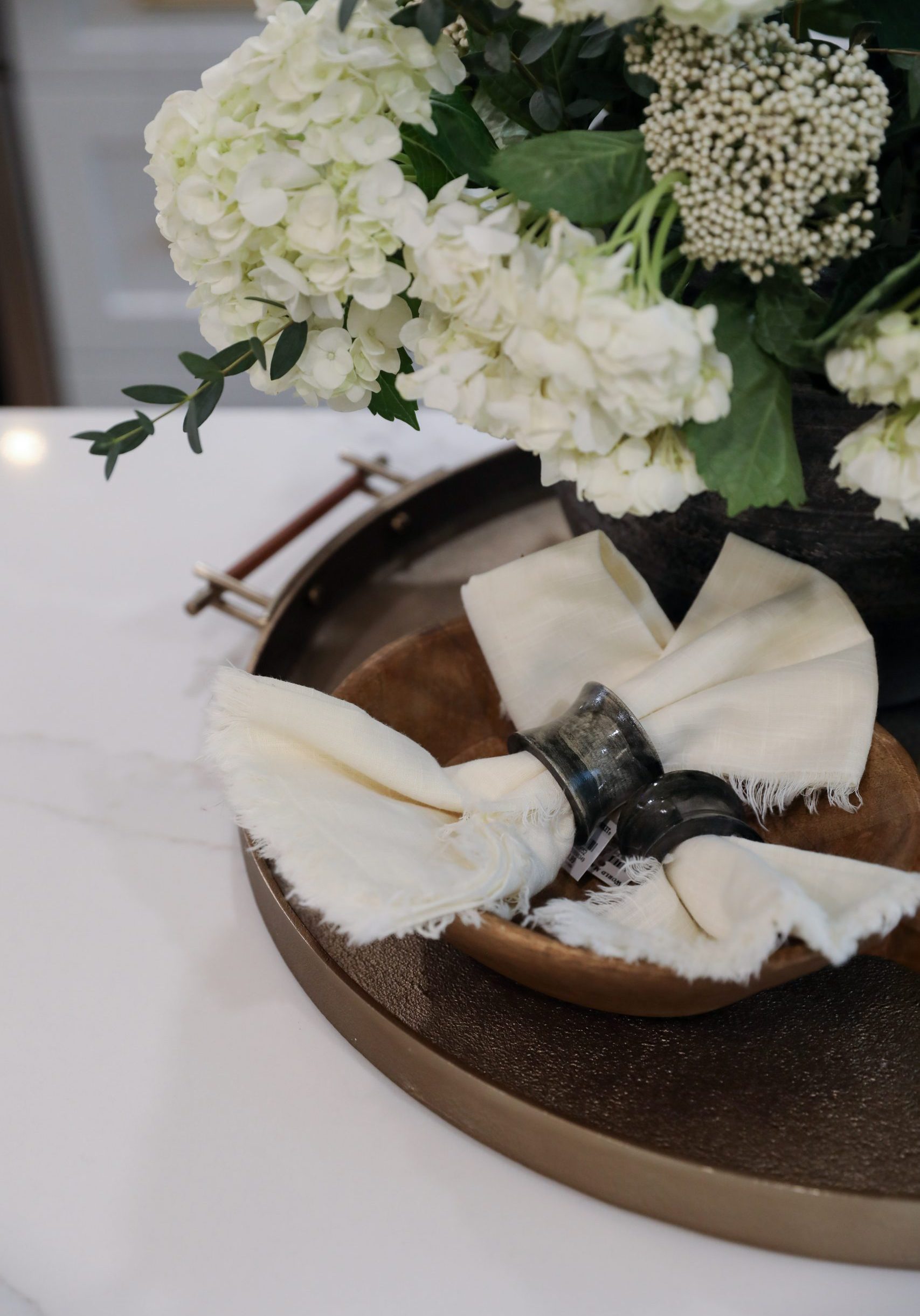 Island countertop decor with place settings, flowers, and trays.